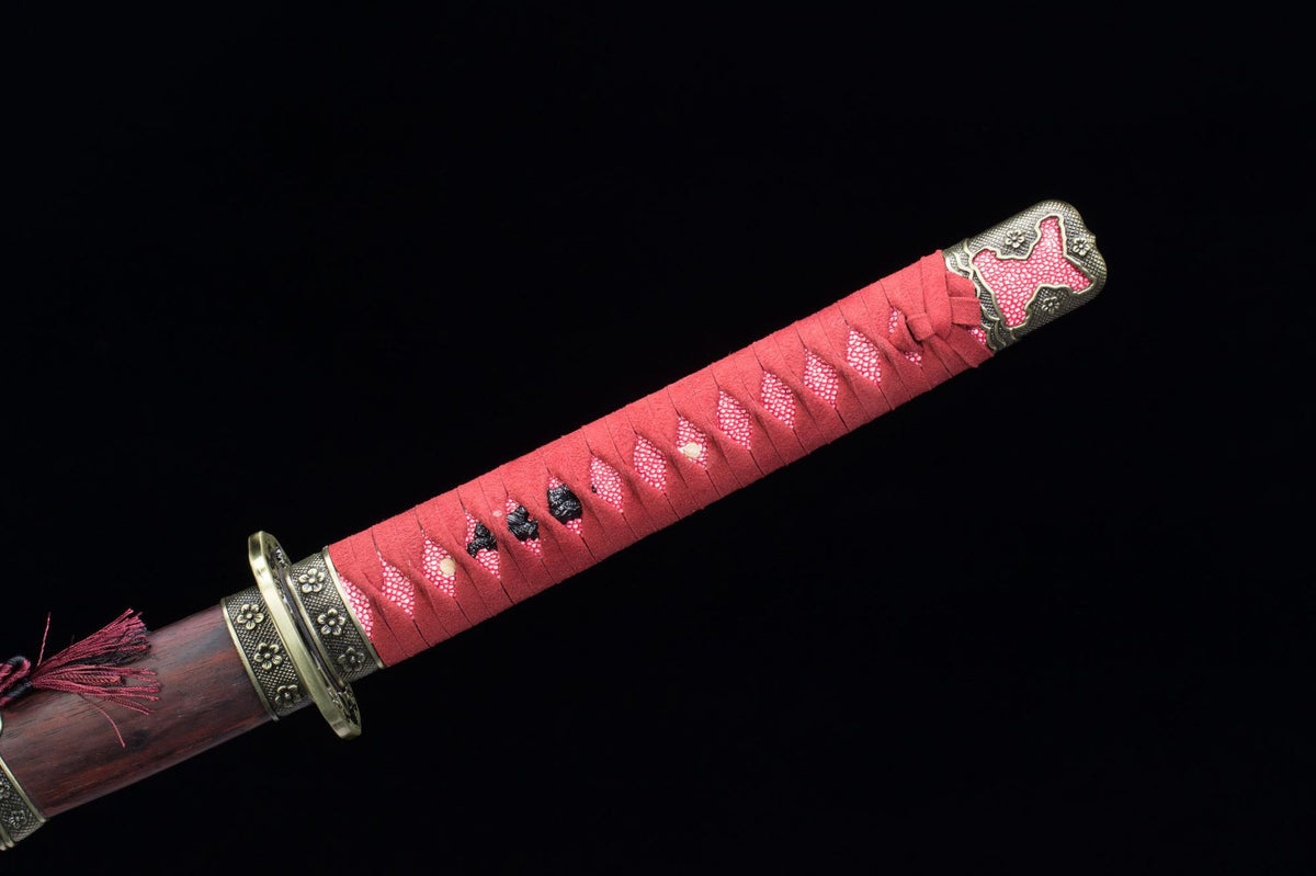 Close-up of the Raijin Katana’s red wrapped handle, decorative guard, and aged wood saya