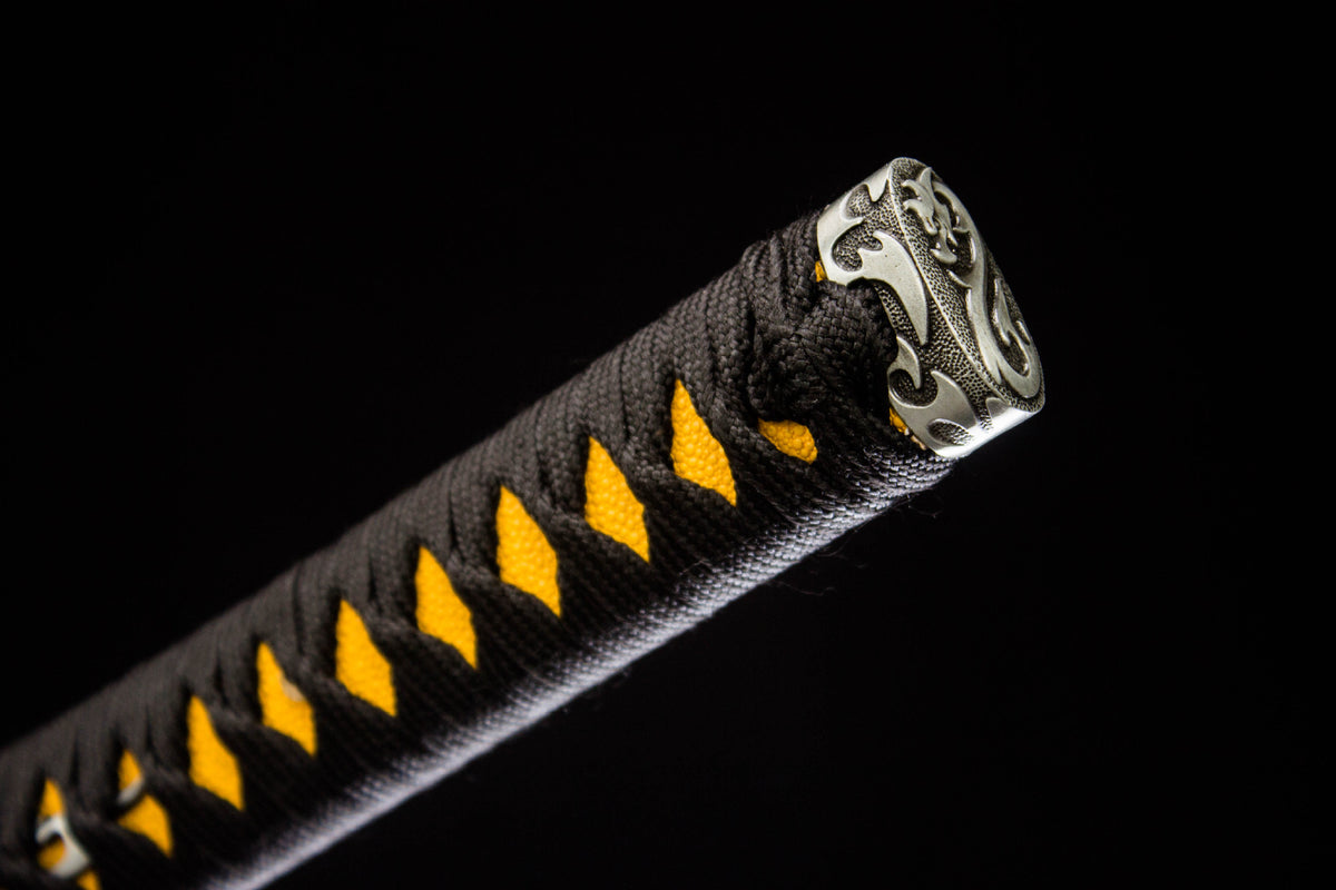 Close-up of the Gilded Dragon Katana’s black and gold handle wrap with an ornate end cap