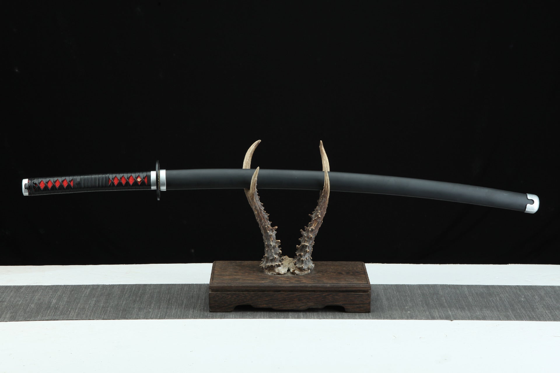 Showcase of Tanjiro's obsidian black Nichirin blade, featuring black design with silver fittings.
