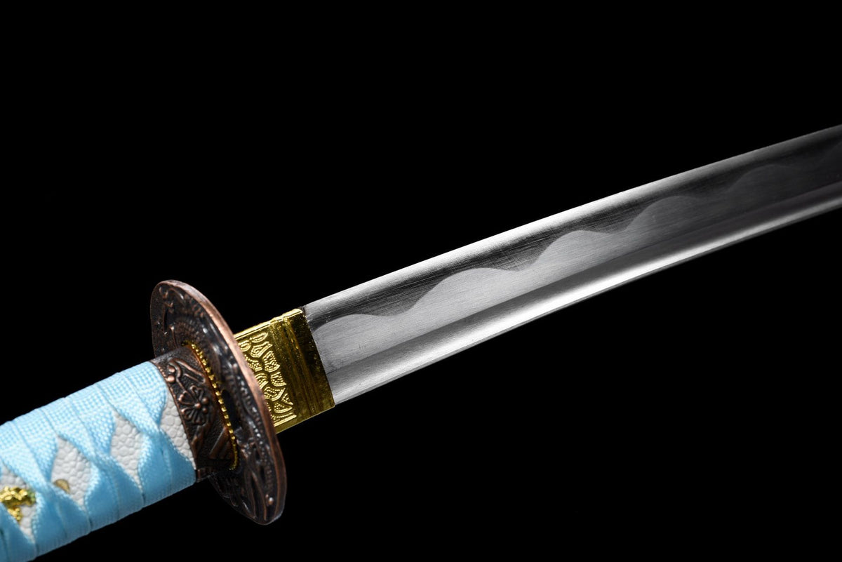 Polished blade base with decorative wavy line and gold-toned fittings
