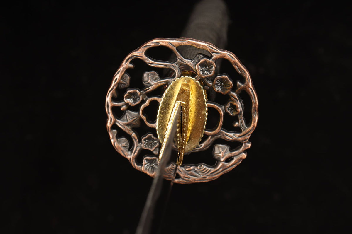 Round flowering-branch sukashi tsuba on the Emberflow Katana
