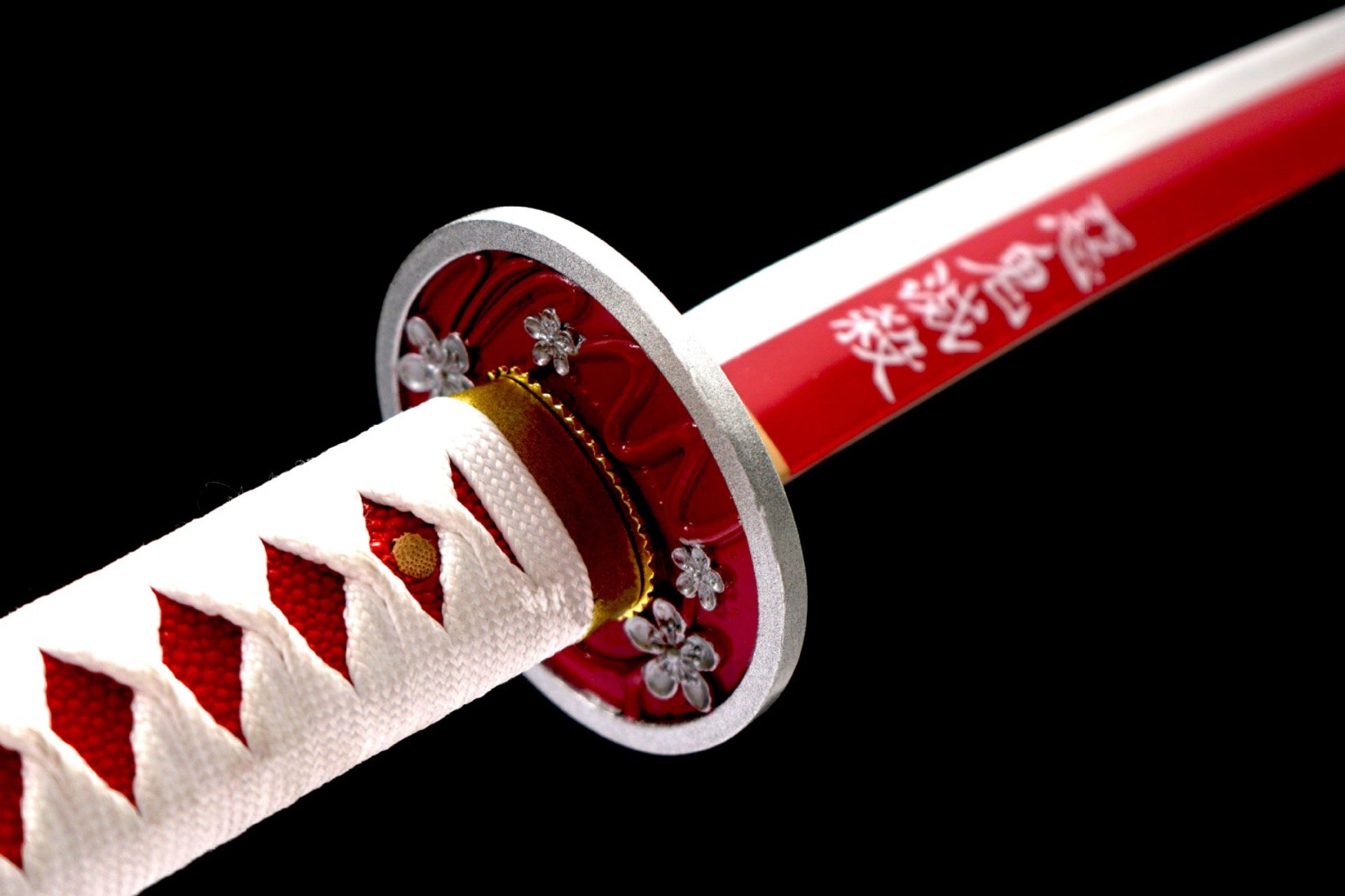 Red flower-motif guard and Japanese character detail on the red-and-white blade