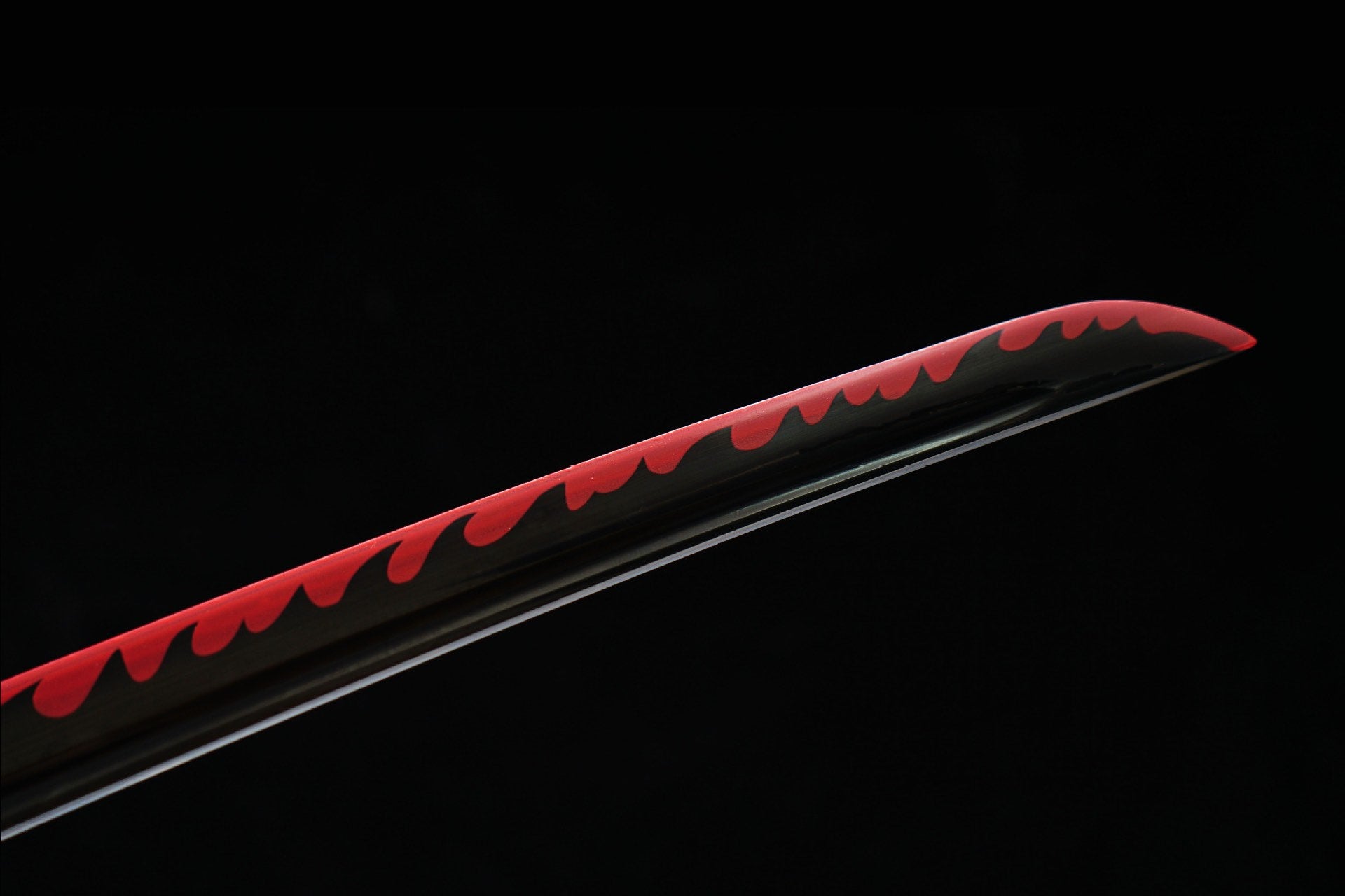 Close view of the black blade with red flame-shaped decorative surface design