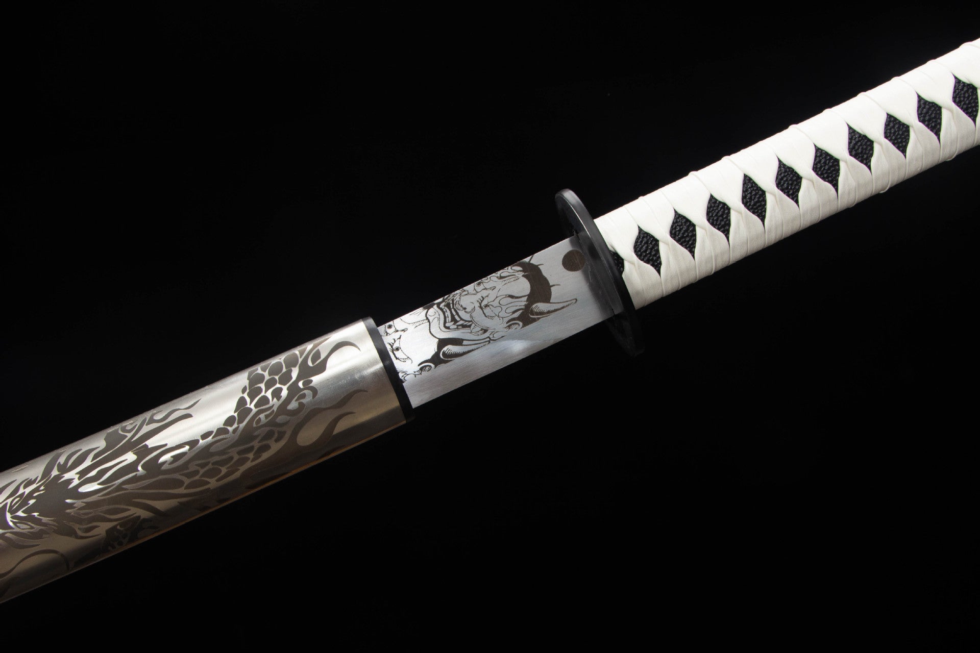 Close-up of Mirror Dragon Katana blade base, black tsuba, and white tsuka wrap