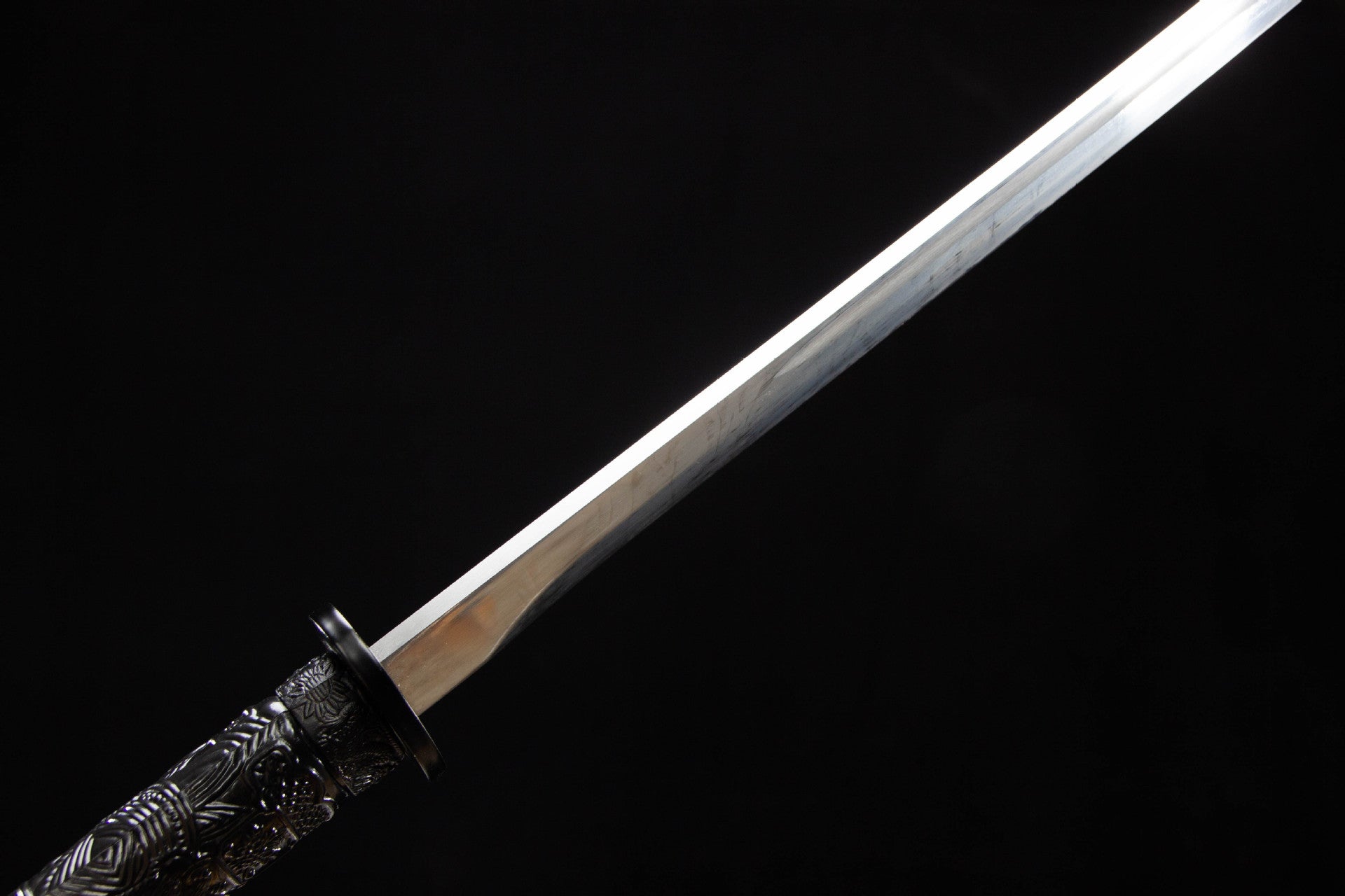 Polished manganese steel blade near the black iron guard