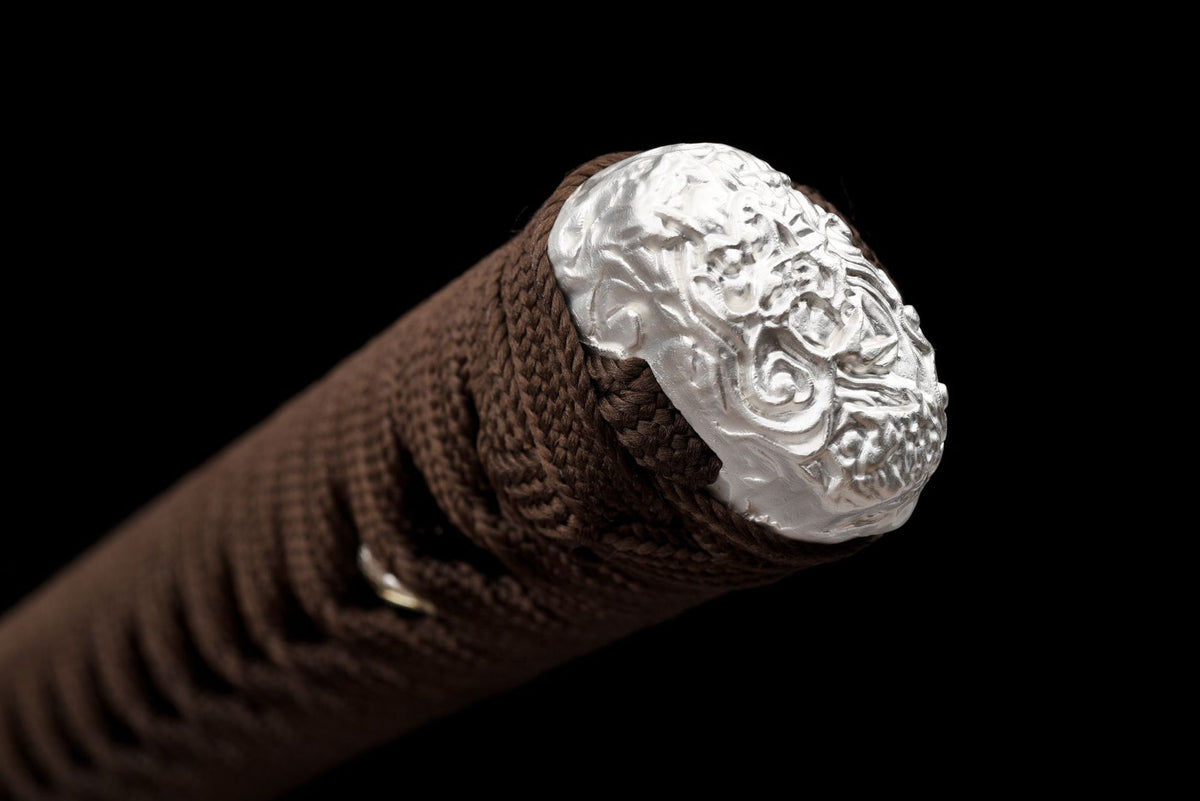 Relief-decorated kashira on the brown wrapped tsuka