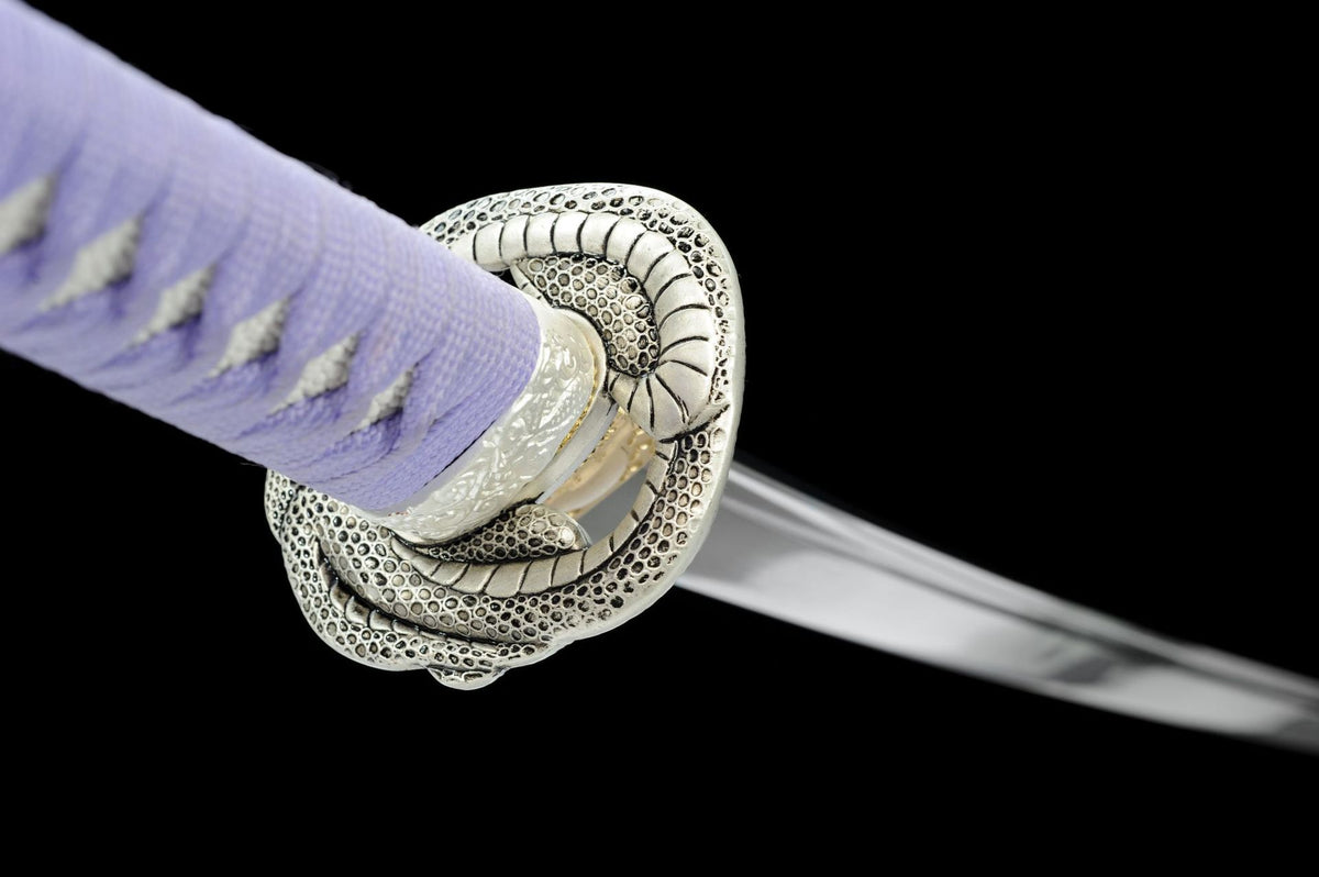 Coiled-serpent relief tsuba with dark recessed scale detail