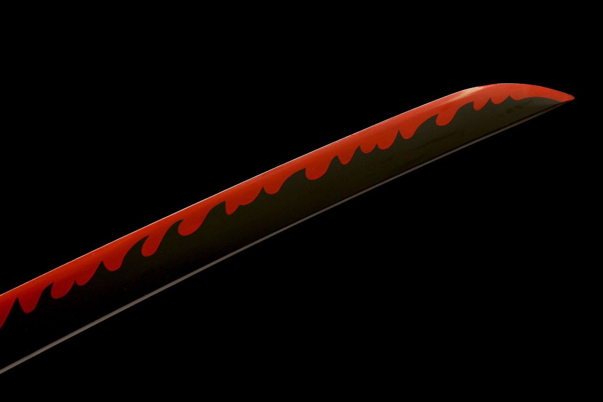 Close view of the black blade with red flame-shaped decorative surface design