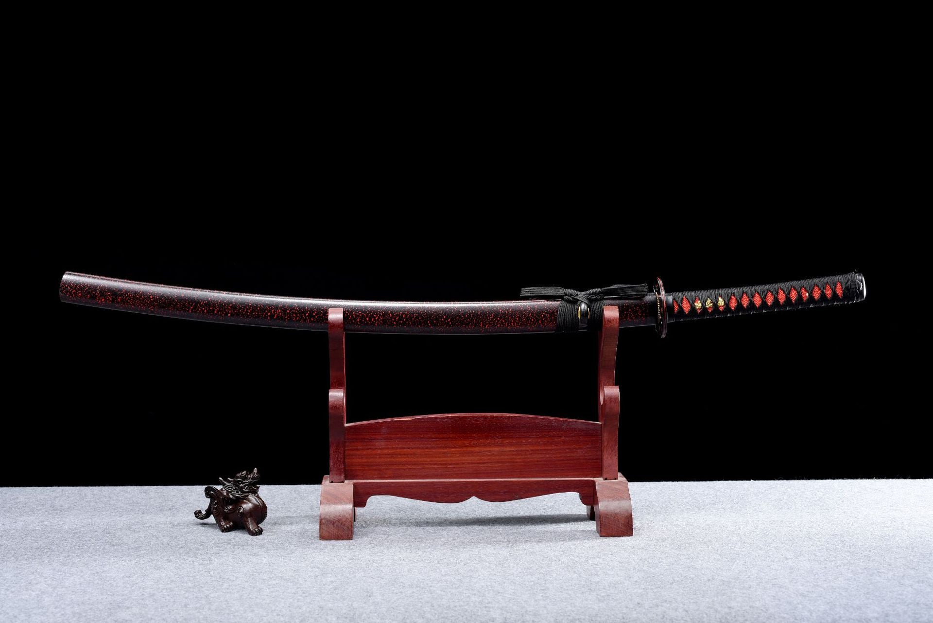 A complete view of the black-red katana sheathed in its saya, showcasing the elegant design and craftsmanship.