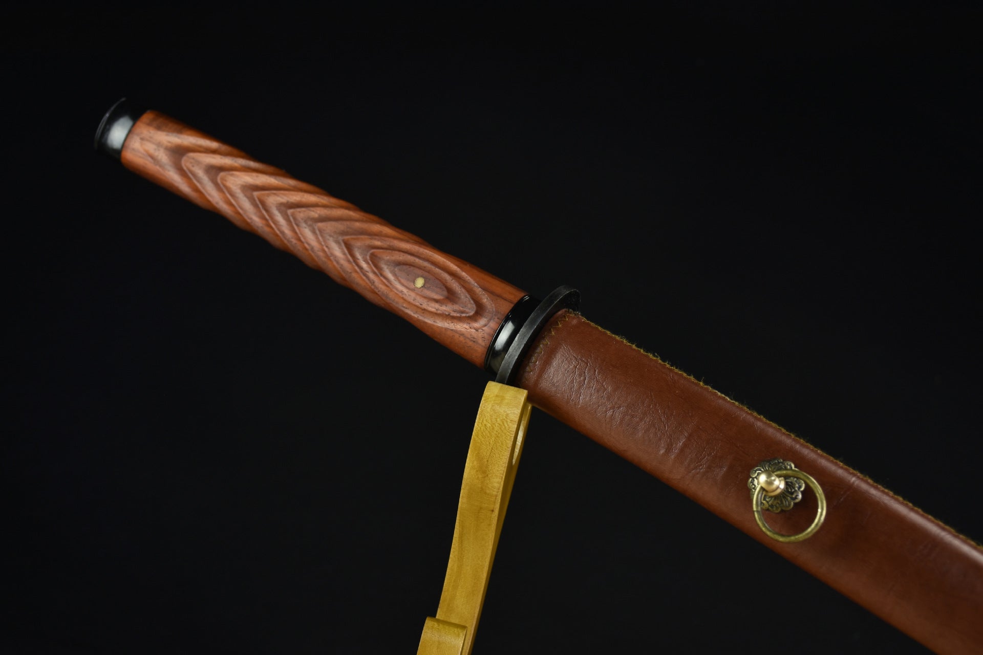 A brown leather katana scabbard paired with a wooden handle