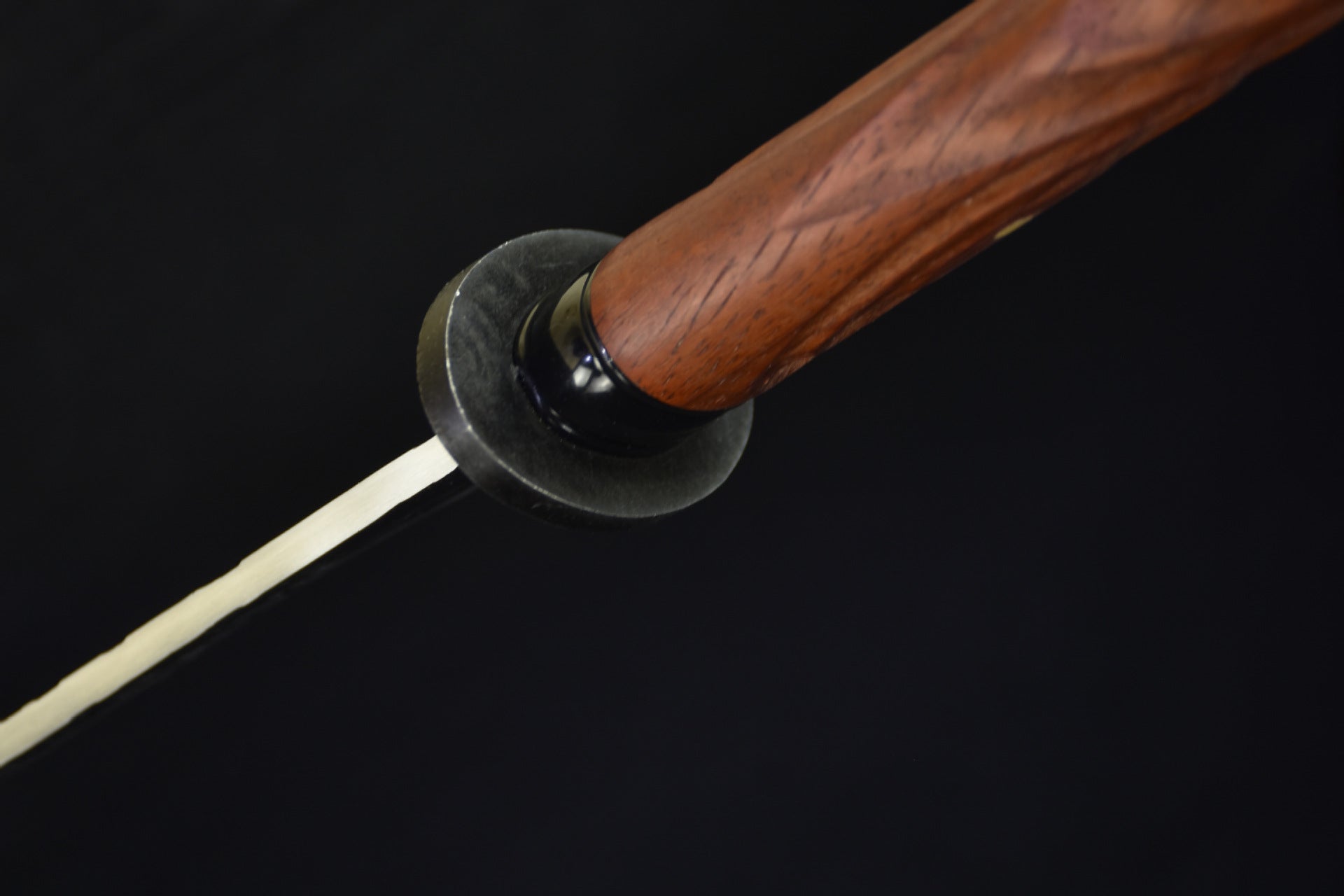 A close-up view of a katana featuring a small hand guard