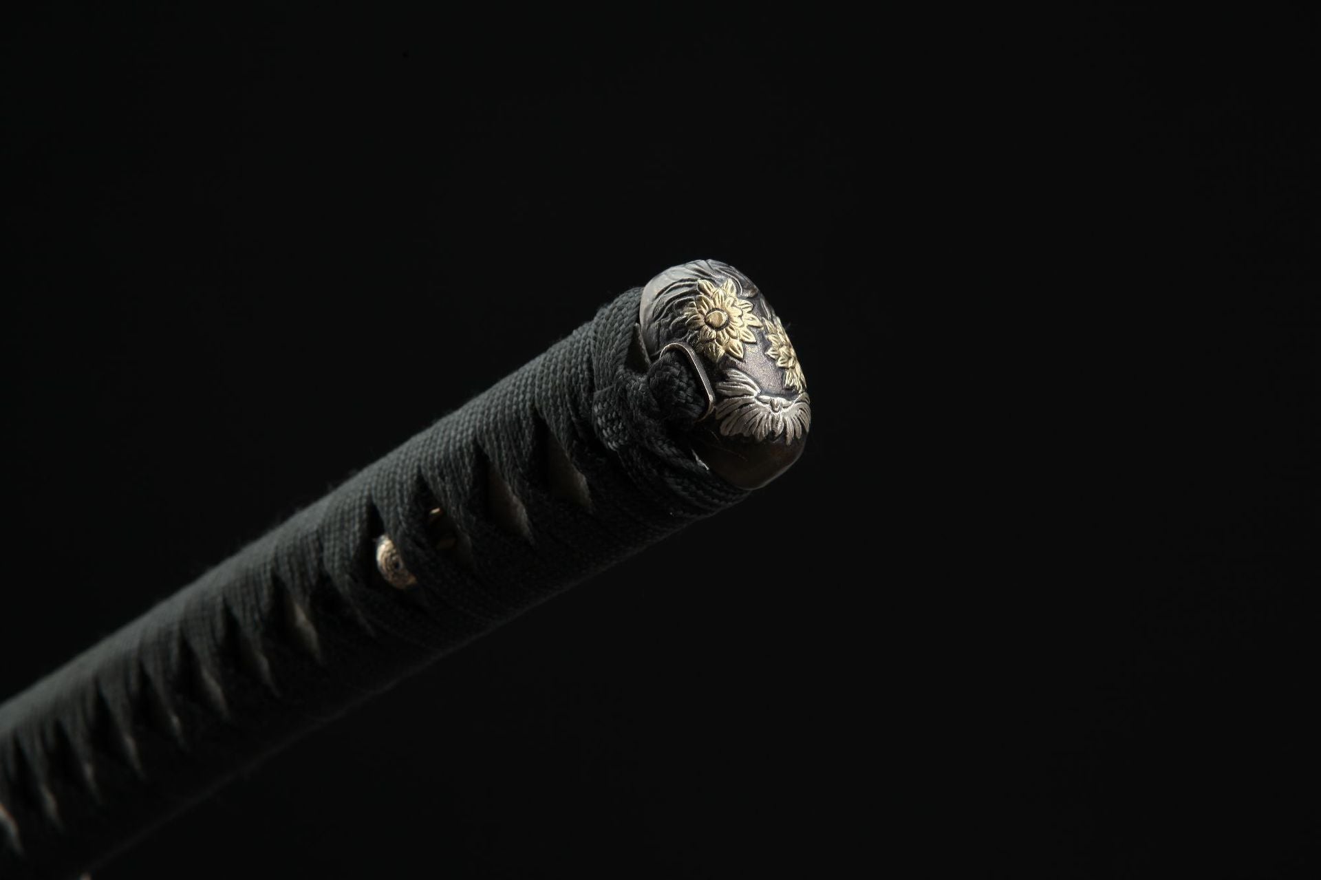 Close-up of the daisy kashira, showing intricate engraving details on the pommel