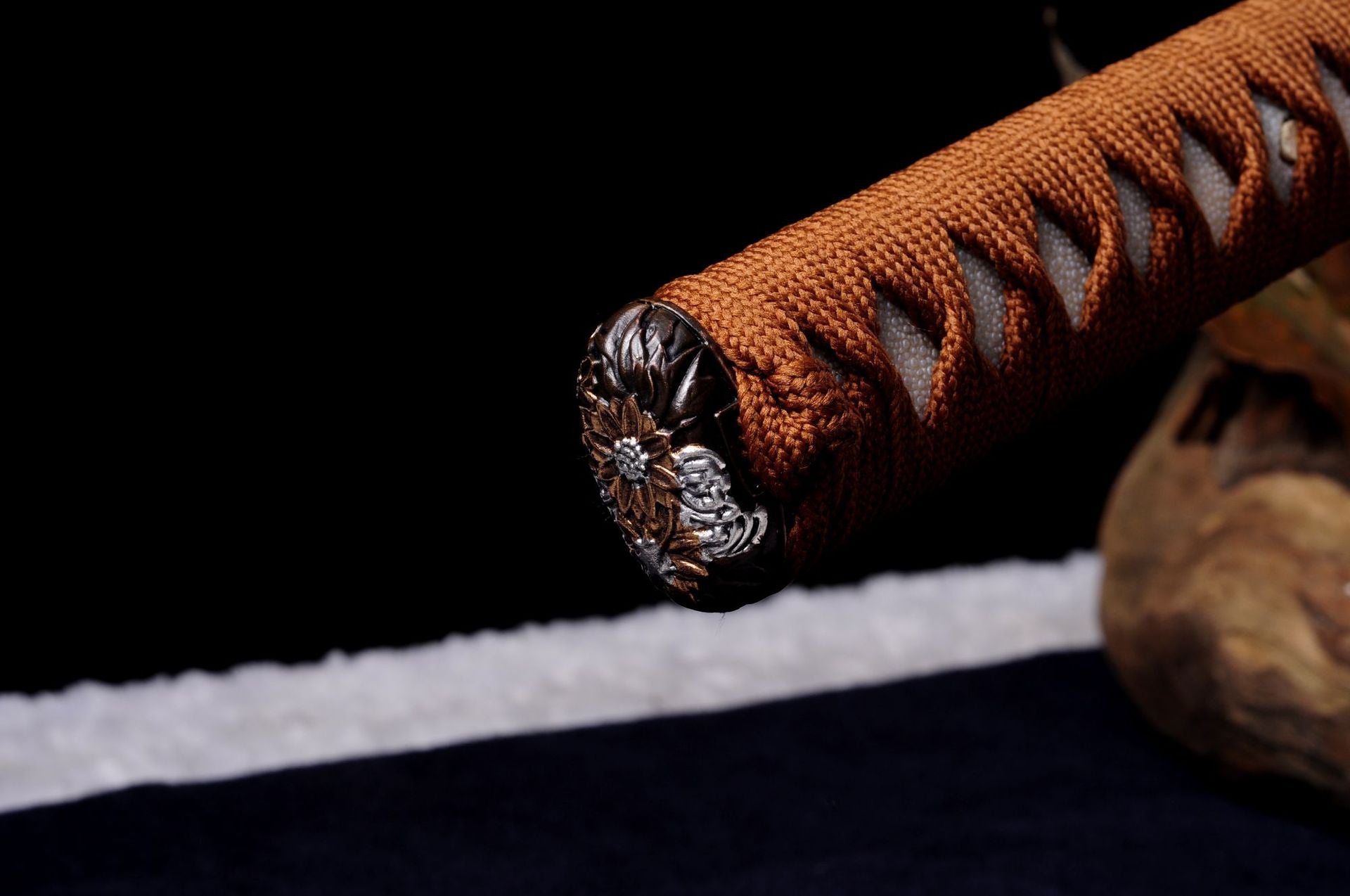 Decorative kashira on Daisy katana featuring intricate floral engravings.