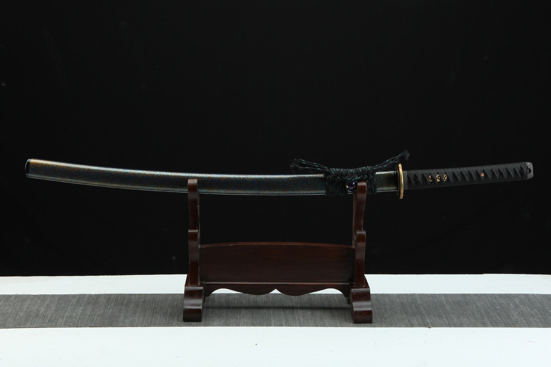 Full view of a Magatama katana with a premium urushi lacquered scabbard displayed on a wooden stand.