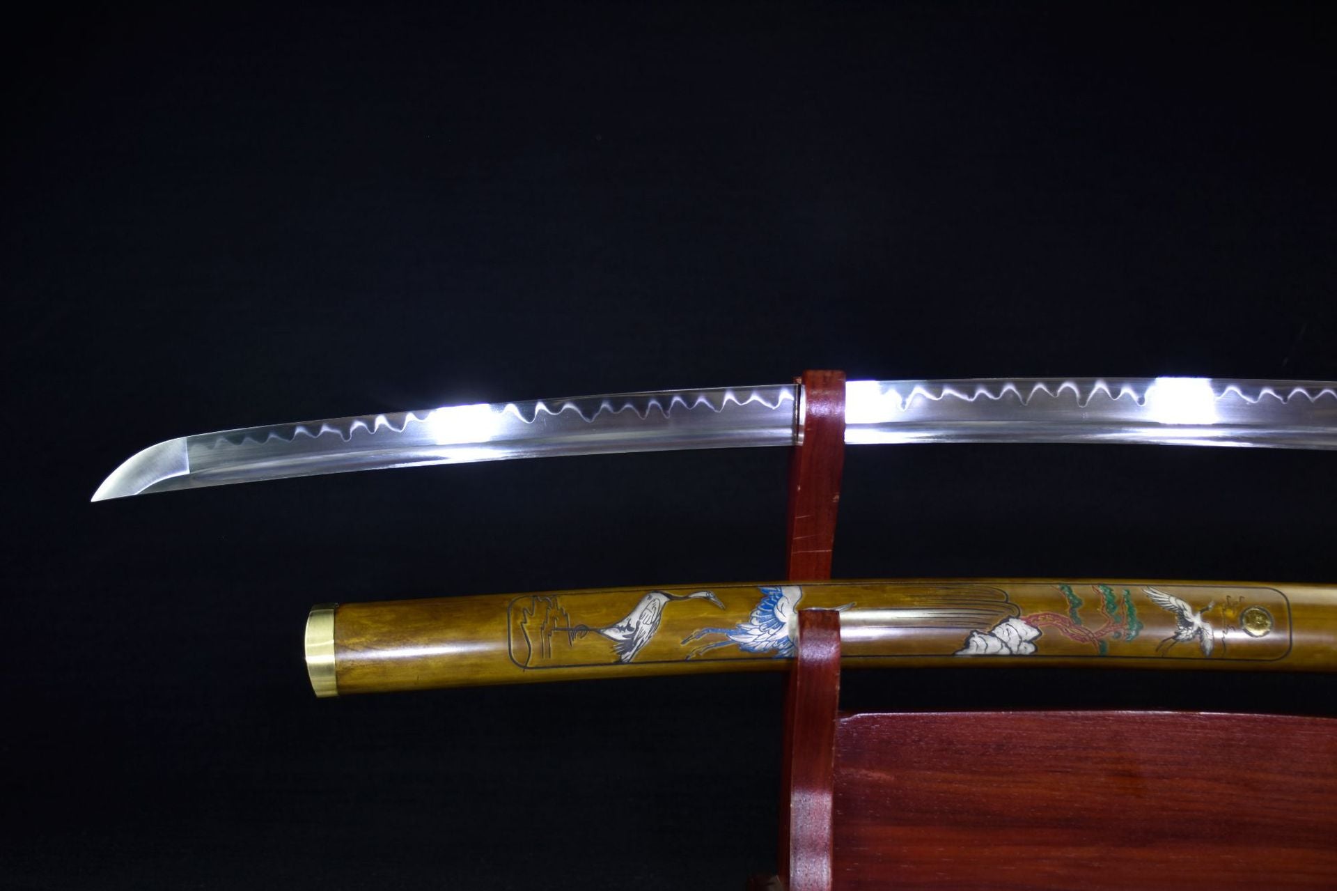 Ichiro Matsuru katana sword with a polished blade featuring a wavy hamon pattern and an artistic sheath with crane designs.