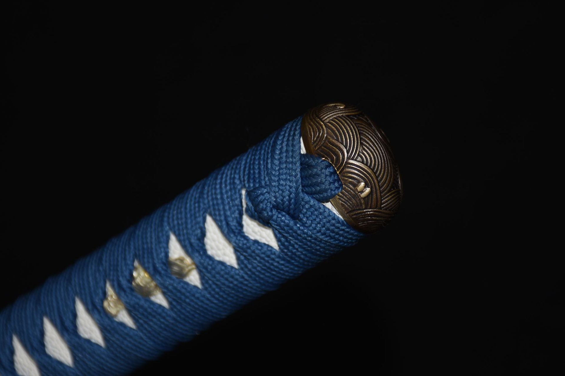 Close-up of the Ichiro Matsuru katana's tsuka end with a decorative kashira featuring wave patterns and blue wrapping.