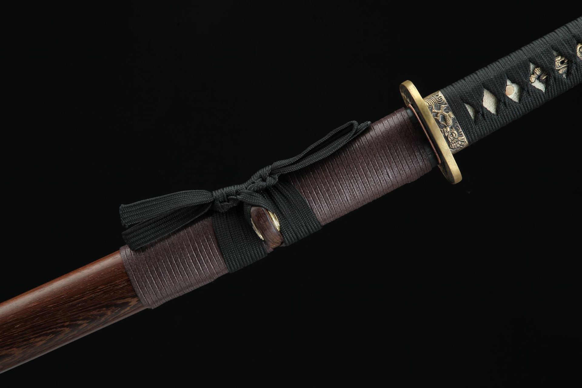 Close-up of the Jiang Tai Gong katana showing the joint between the wooden saya and the tsuka, featuring black sageo cord and textured wooden scabbard.