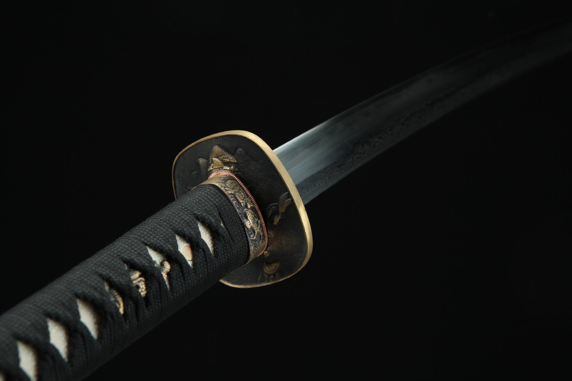 Close-up of the Jiang Tai Gong katana featuring black tsuka with white accents, and an ornate brass tsuba.
