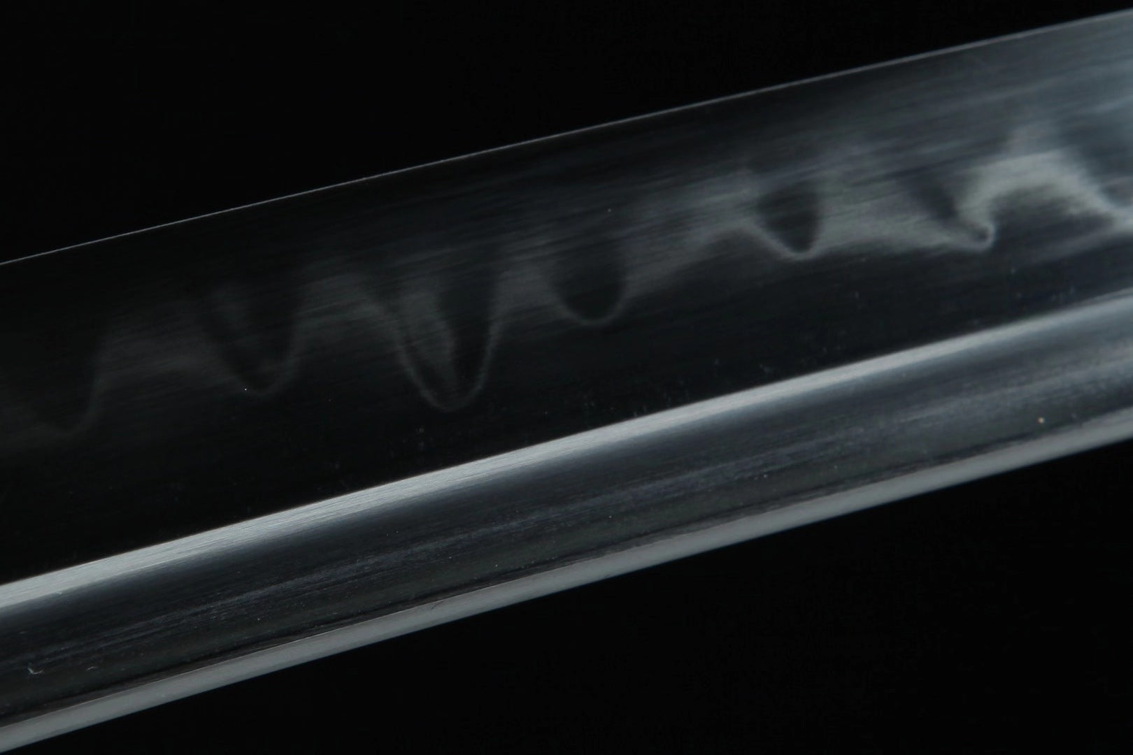 Close-up of the katana blade hamon, highlighting the distinct and intricate tempering pattern.