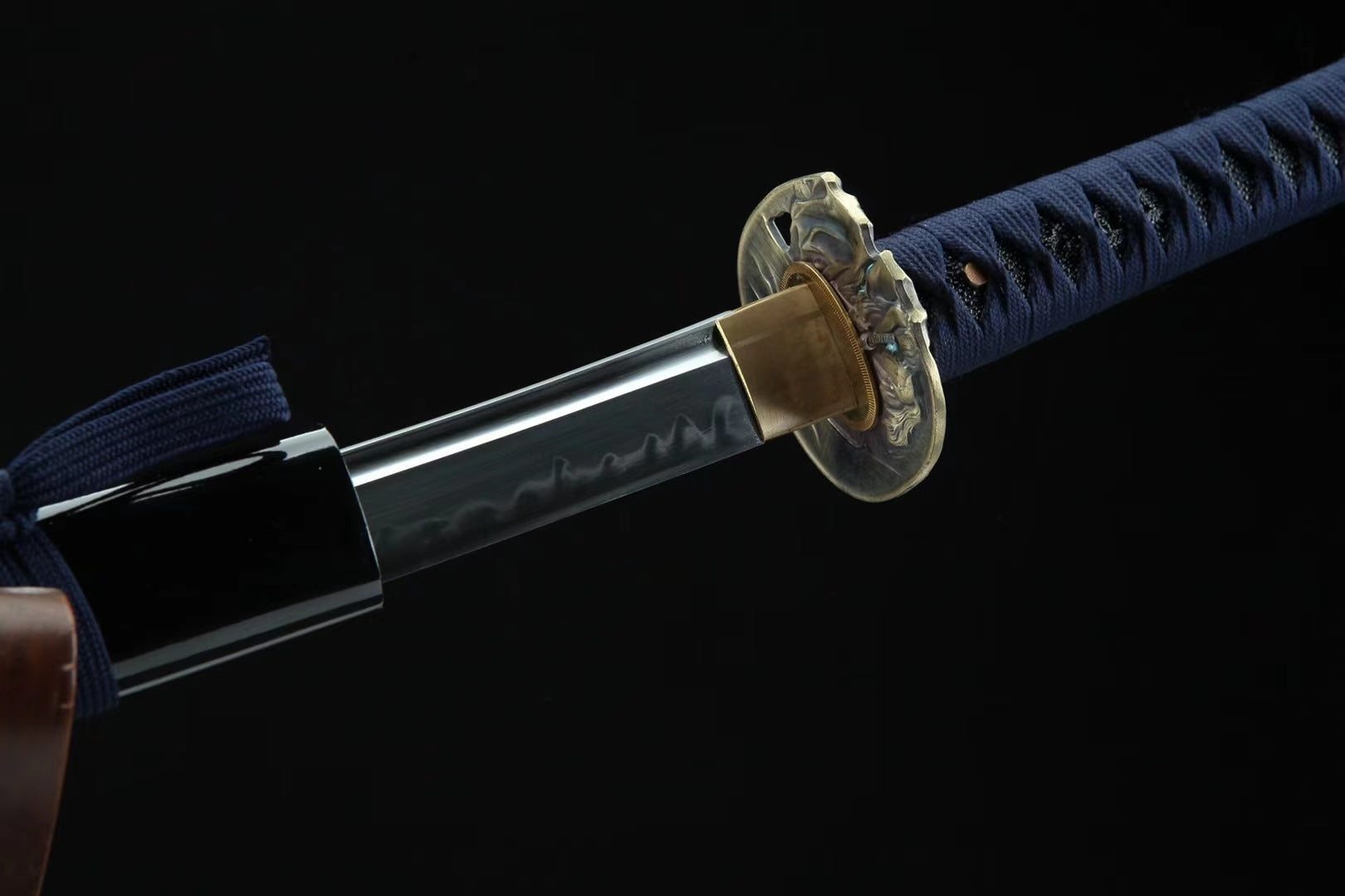 A katana slightly drawn from its saya, showcasing the elegant curvature of the blade and the intricate craftsmanship.