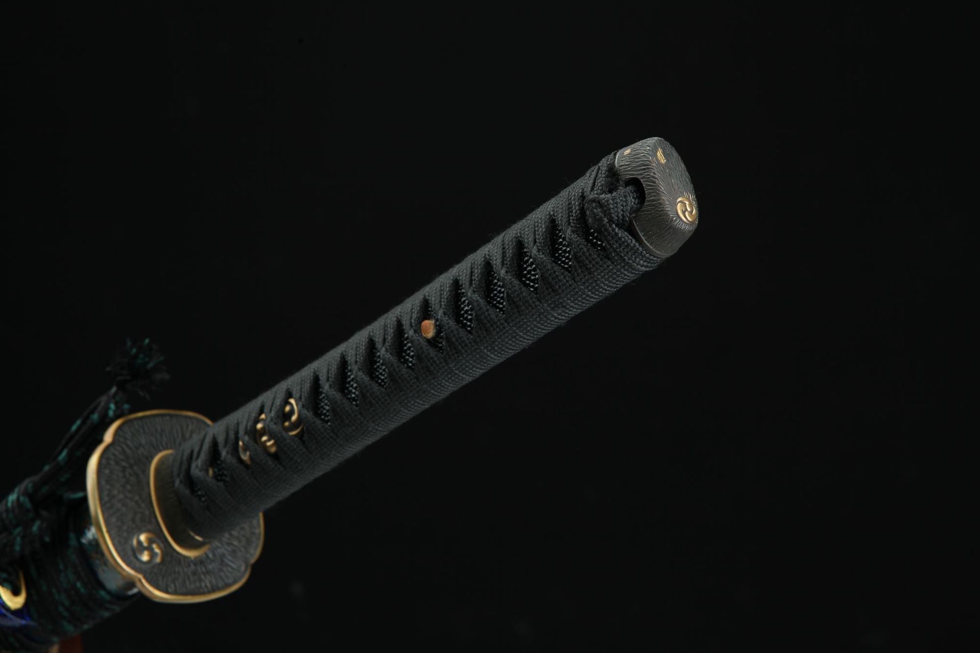 Close-up of the Magatama katana handle showcasing a tomoe-themed menuki design.