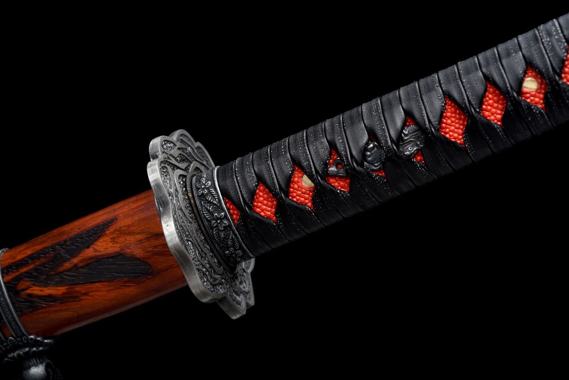 Close-up of the finely crafted black Menuki of the Mortal Blade from Sekiro.