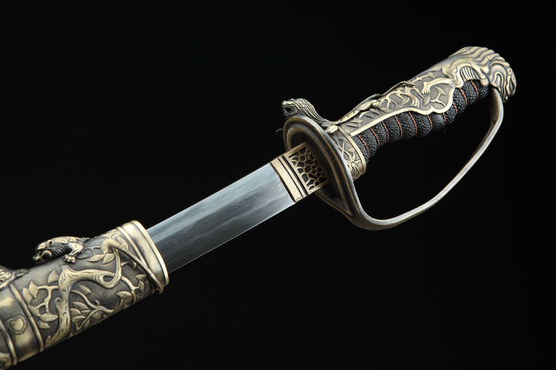 Close-up of Nine Lions sword with intricate tsuka fittings and Damascus steel blade.