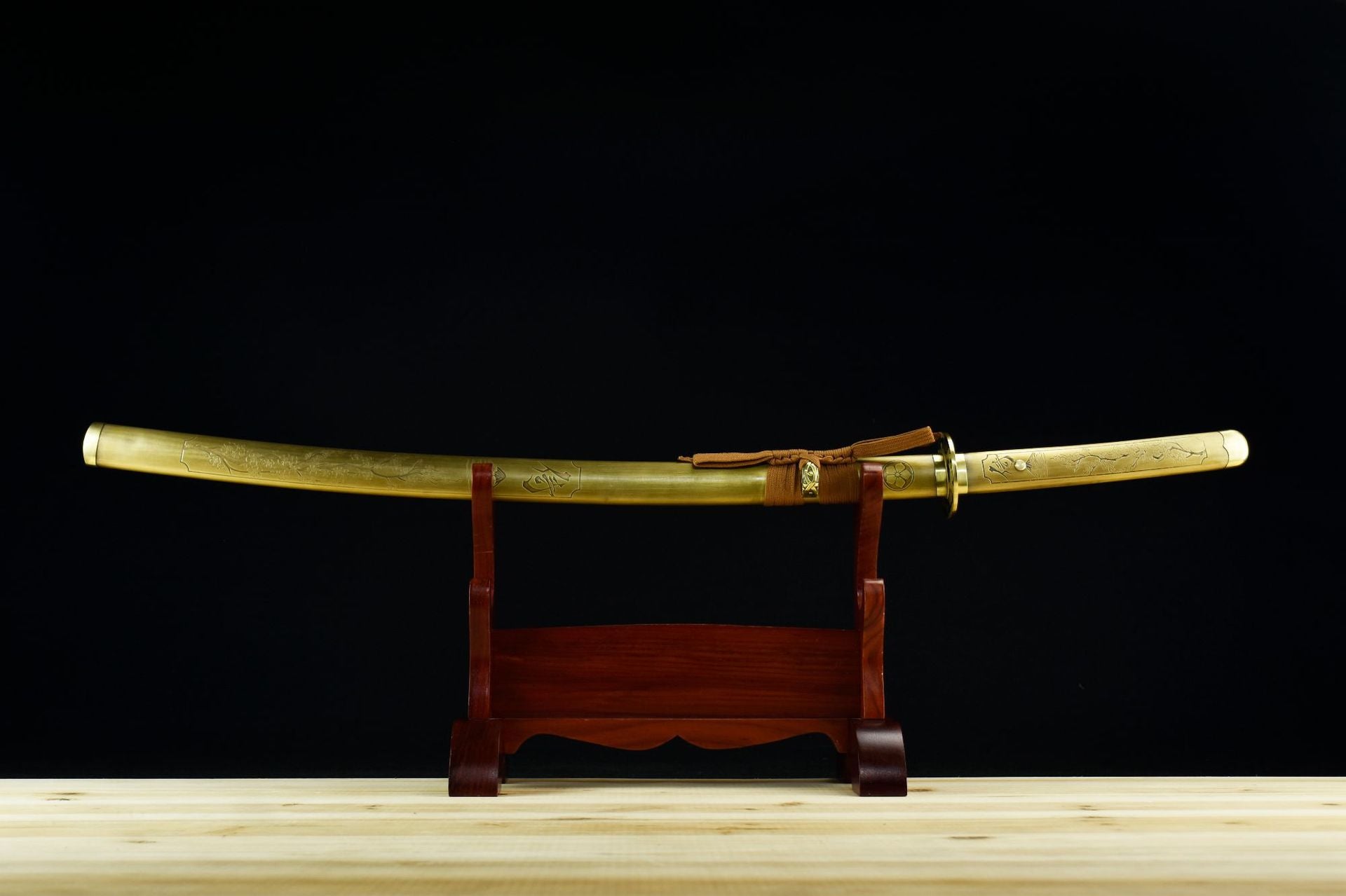 Samurai sword with sakura engraved cpper fittings on a wooden display stand.