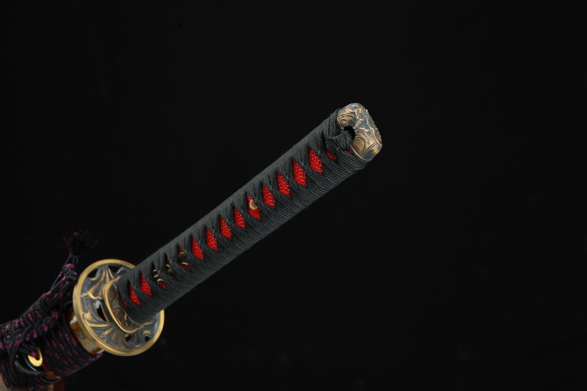 Close-up of the Shinrin Samurai Sword handle cap with detailed metalwork and black and red cord wrapping.