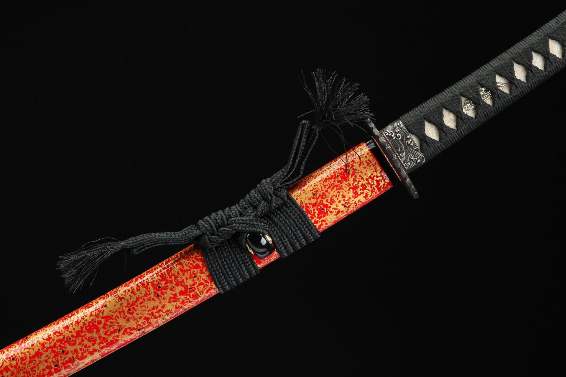 Close-up view of the red lacquer saya with a unique speckled design, featuring a decorative sageo knot.