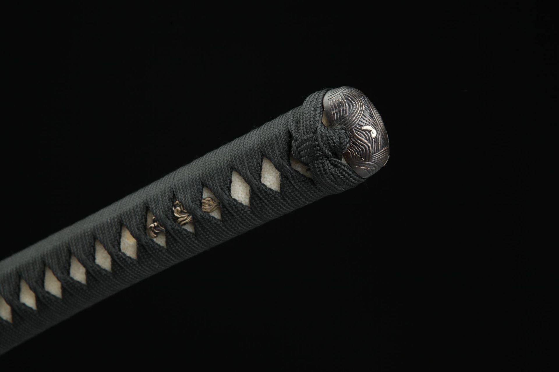 Close-up of the samurai sword handle (tsuka) with black tsuka-ito wrapping, showcasing the menuki and kashira details.