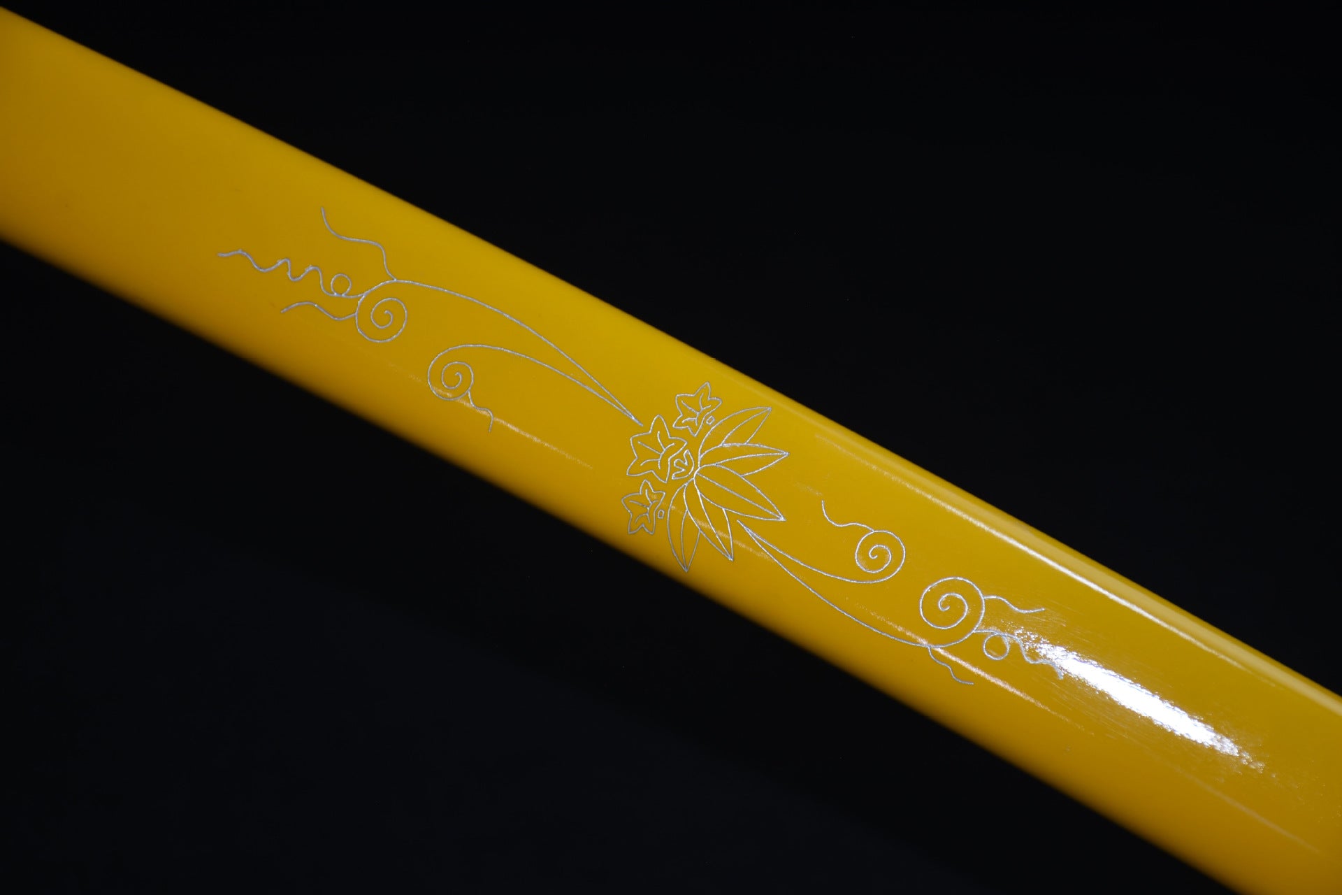 A close-up of a yellow lacquered sword scabbard