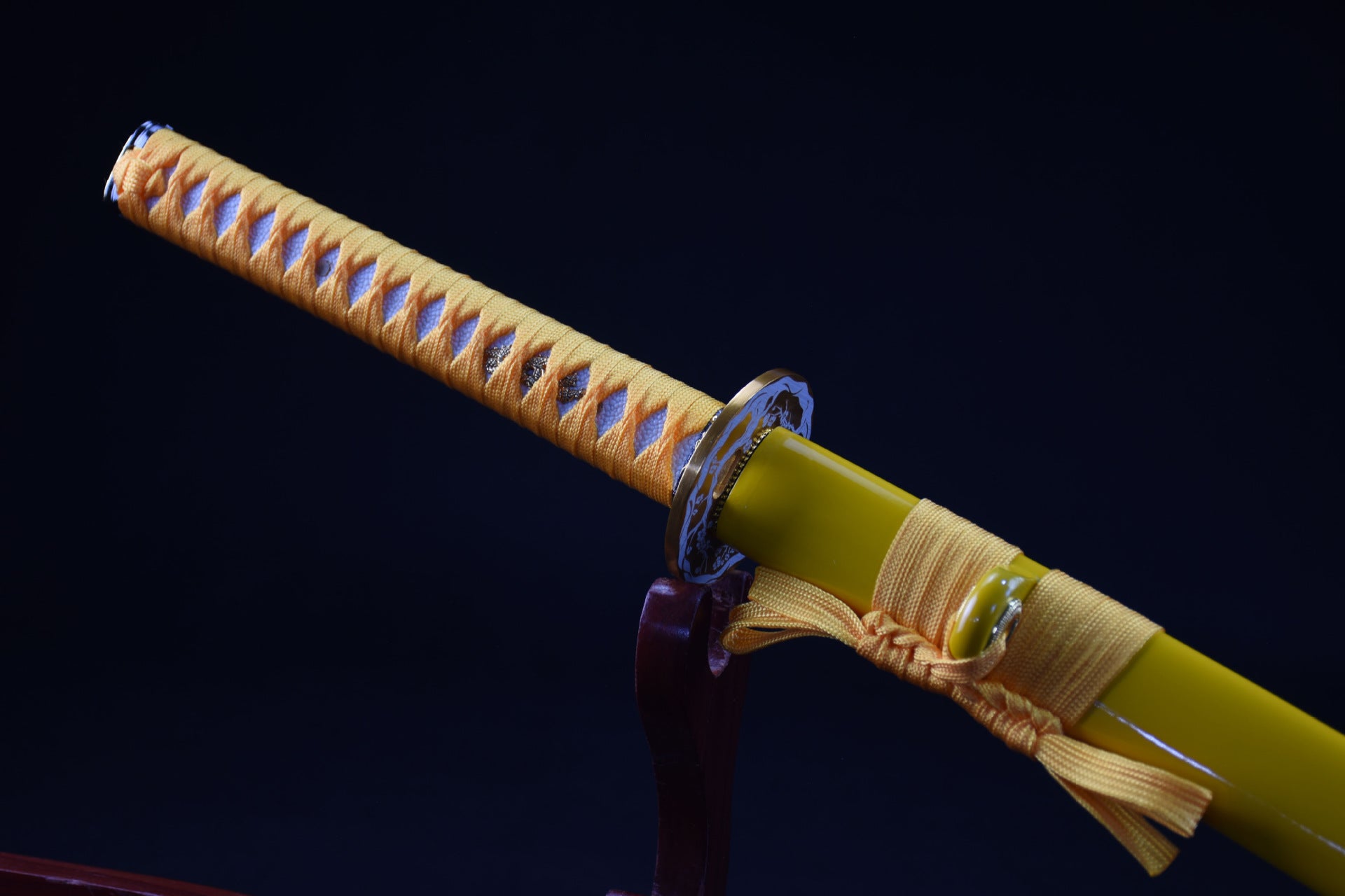A yellow samurai sword handle displayed on a sword stand