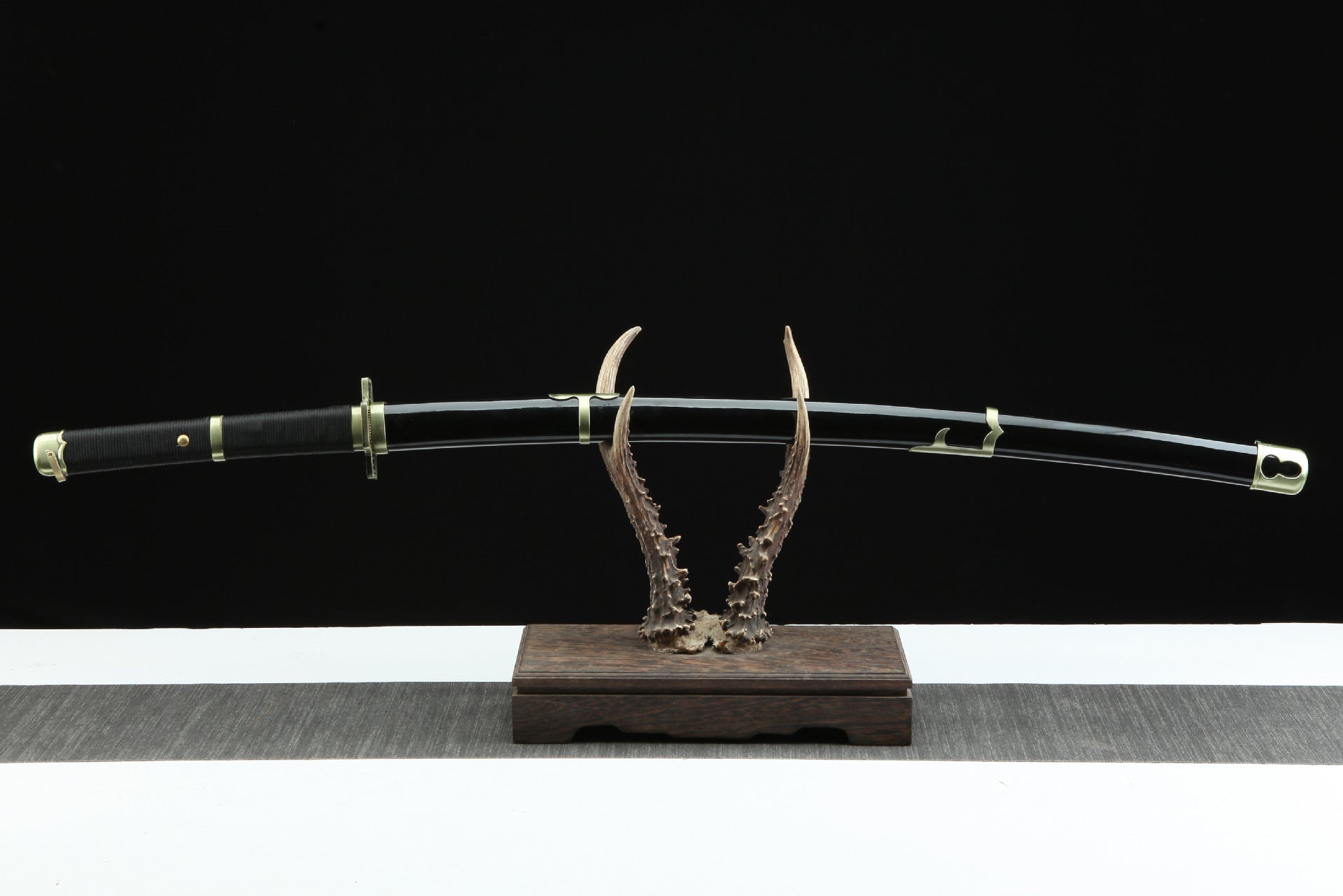 The Yubashiri sword sheathed and displayed on a stand, showcasing its overall design.
