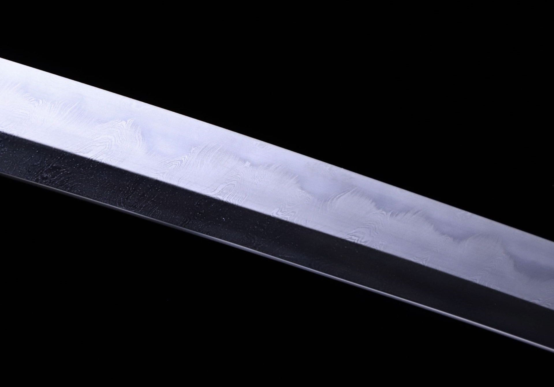 Detailed view of a Damascus steel blade featuring a gunome hamon.