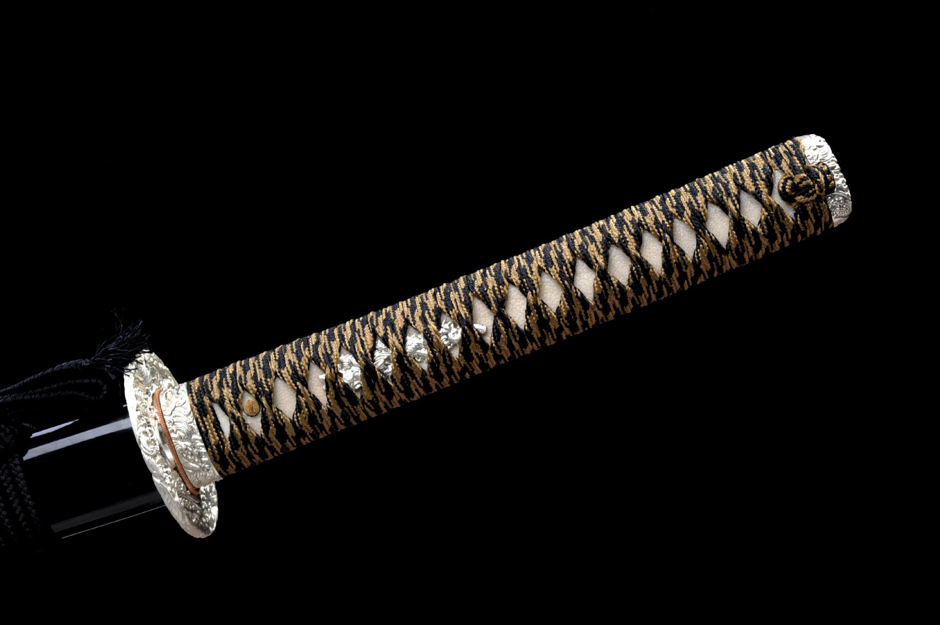Katana handle wrapped in black and gold with intricate menuki.