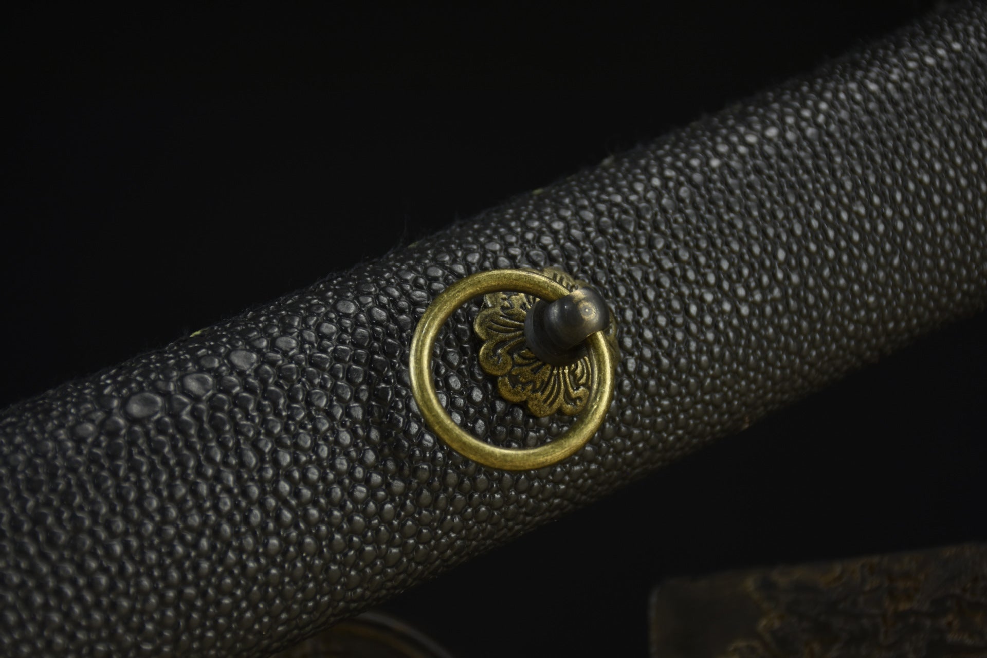 A close-up of a sleek black faux leather scabbard