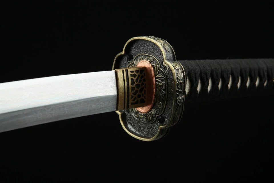 Elegant black and gold chrysanthemum tsuba for katanas, featuring exquisite craftsmanship and traditional Japanese design.