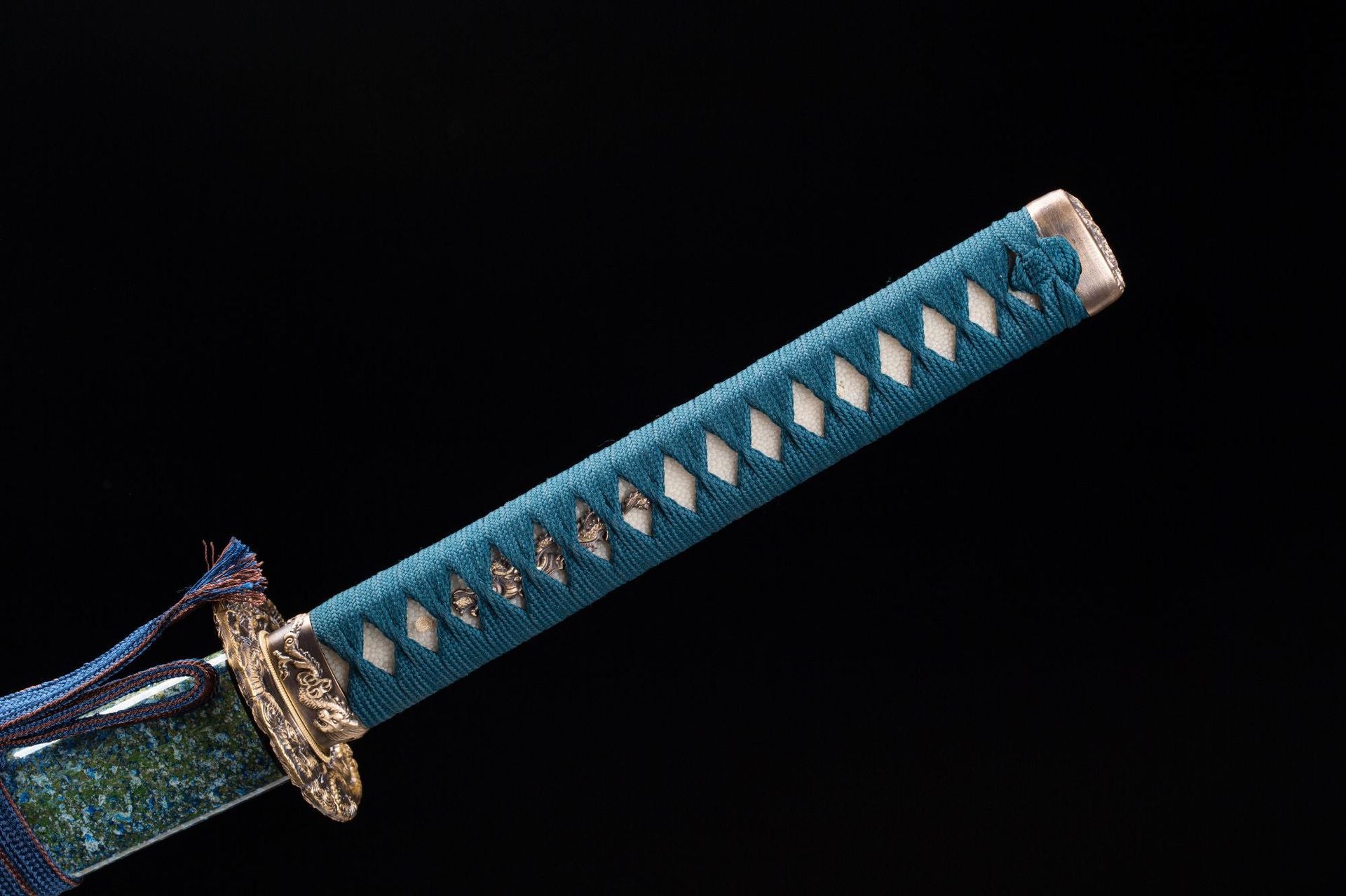 A close-up view of a high-end katana handle wrapped in blue-green cord over white ray skin, showcasing luxurious texture and traditional craftsmanship.