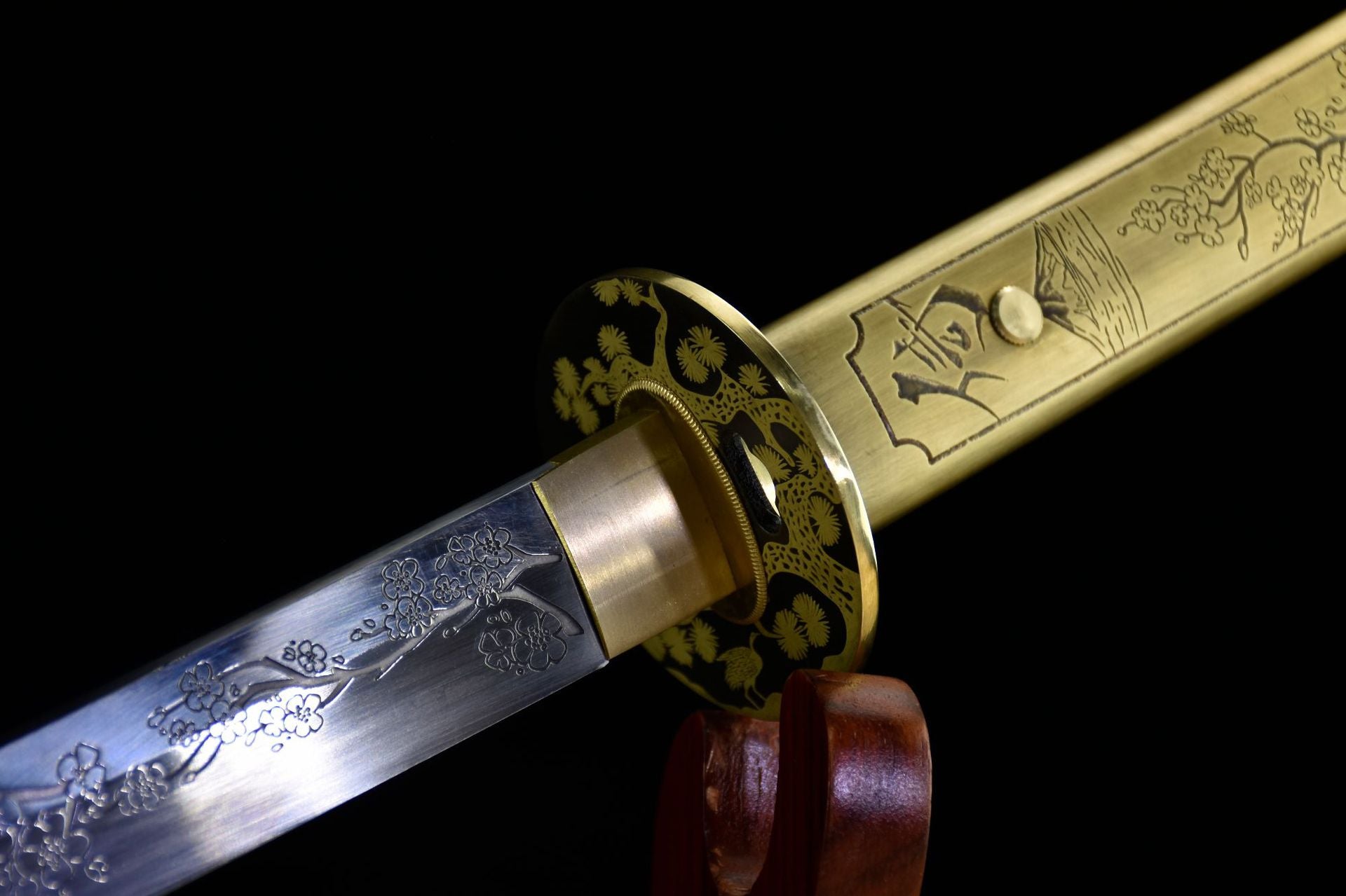 A katana featuring a brass tsuba with intricate sakura engraving, and a beautifully etched blade with floral designs.