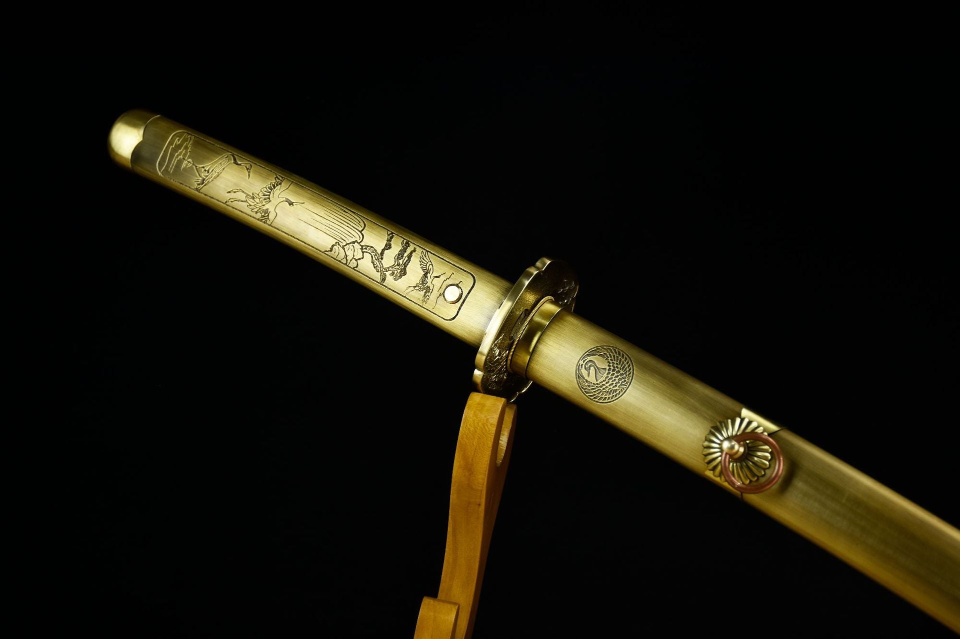 The handle of a copper-fitted katana intricately engraved with a crane, symbolizing elegance and traditional Japanese craftsmanship.
