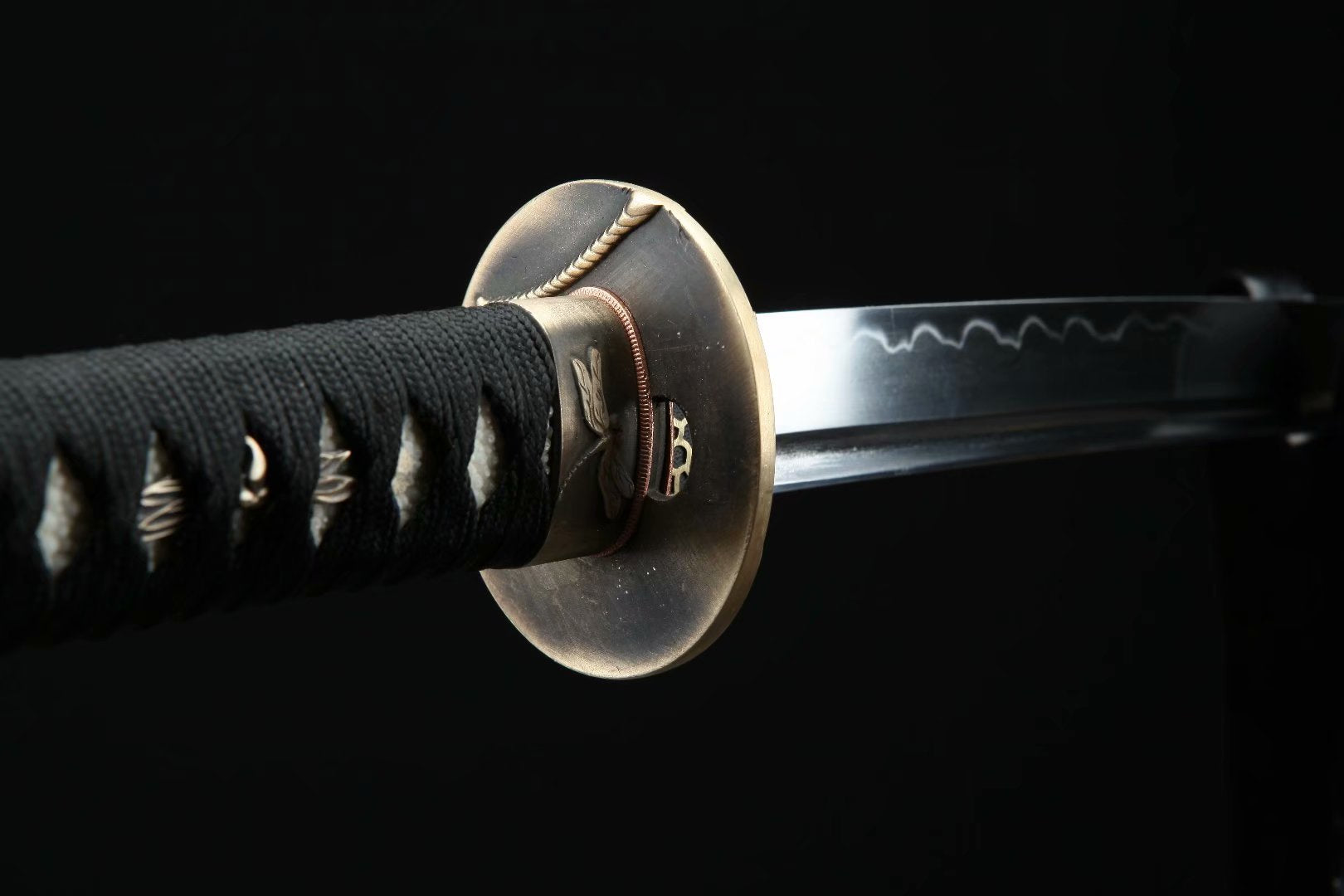 Side view of the Dragonfly Wakizashi tsuba with leaf and dragonfly carvings, showcasing its intricate details.