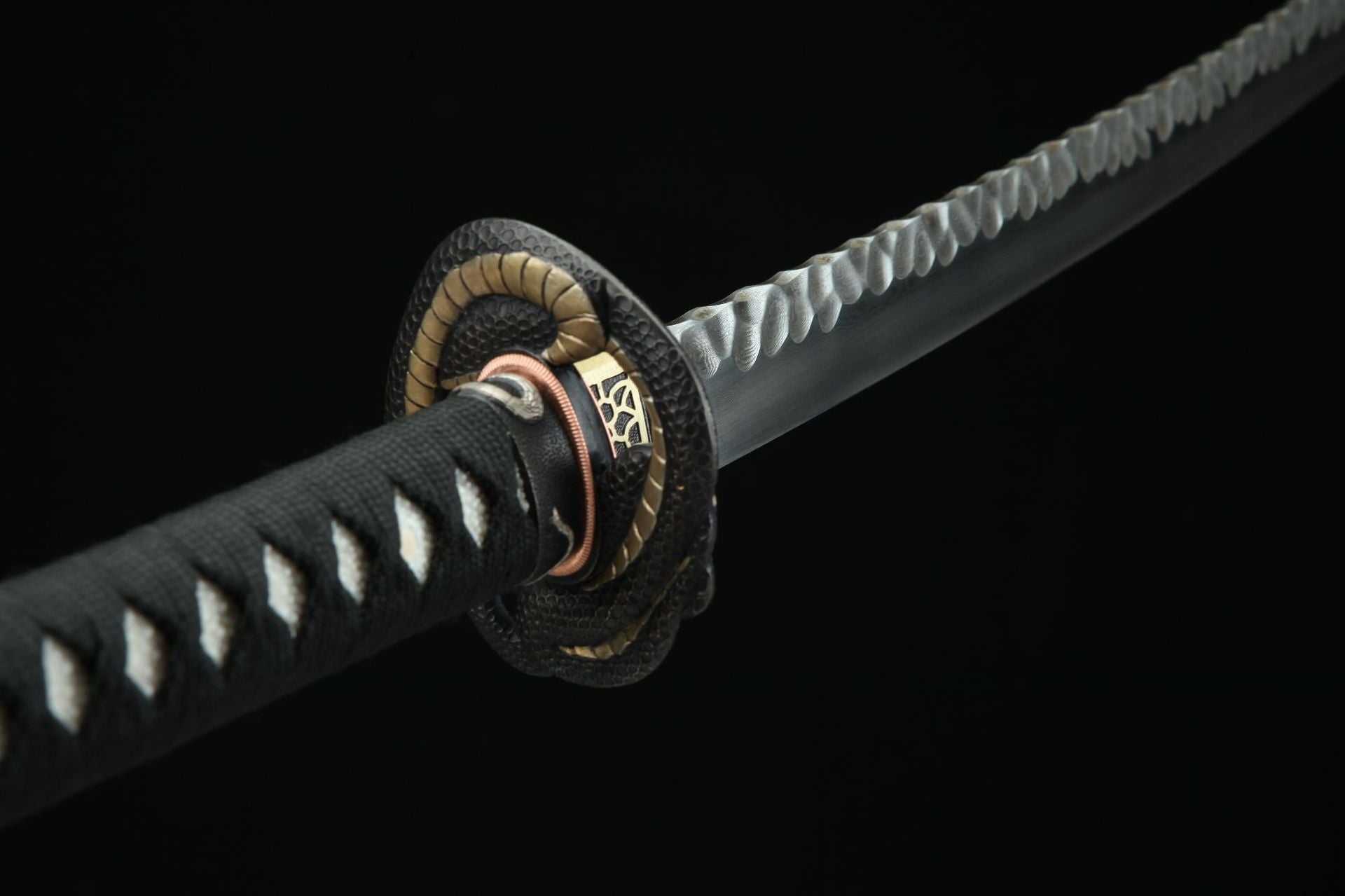 Close-up of Hebi katana tsuba with intricate serpent design, highlighting the craftsmanship