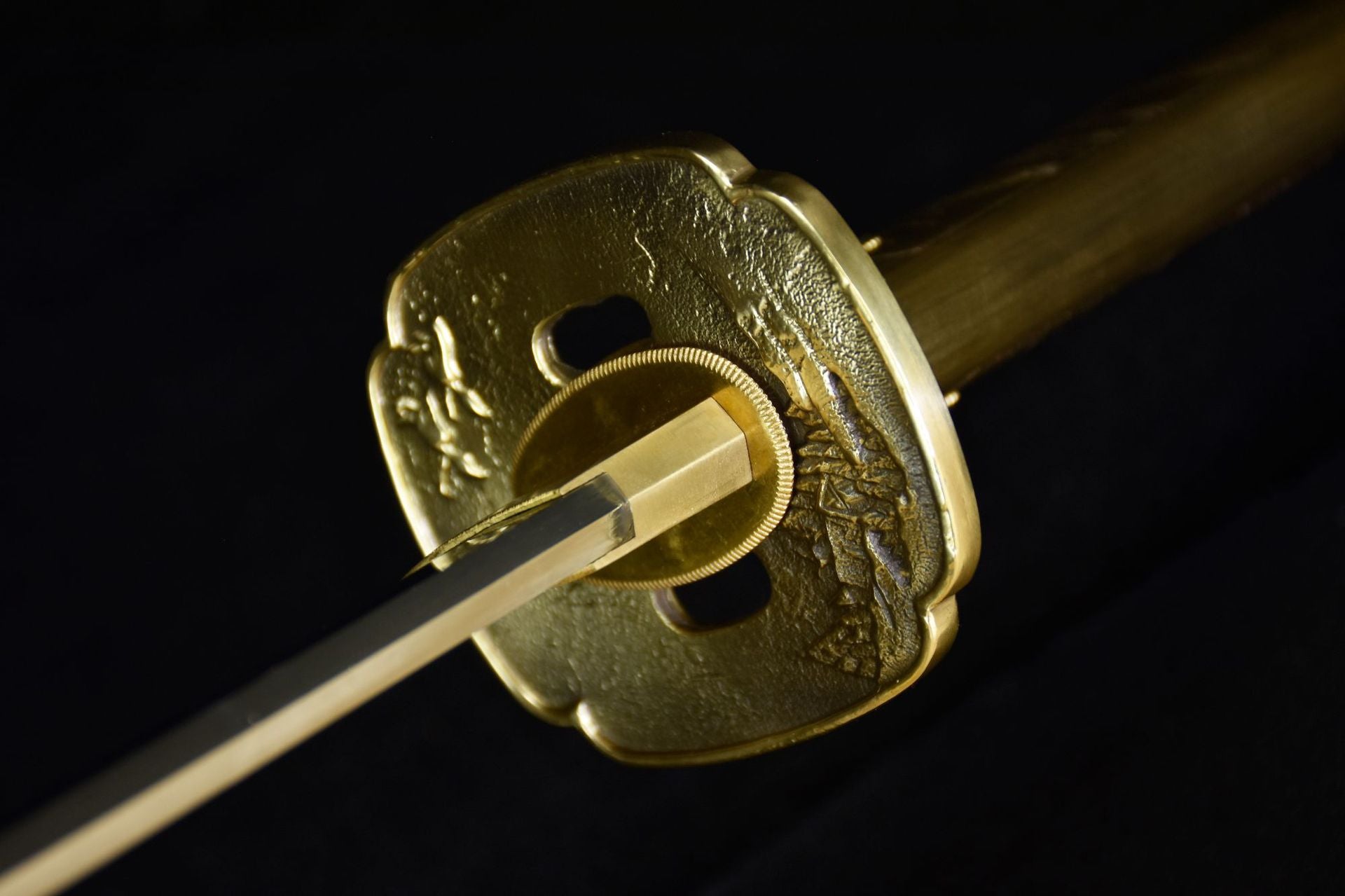 A beautifully engraved brass tsuba on a traditional katana, showcasing intricate craftsmanship.