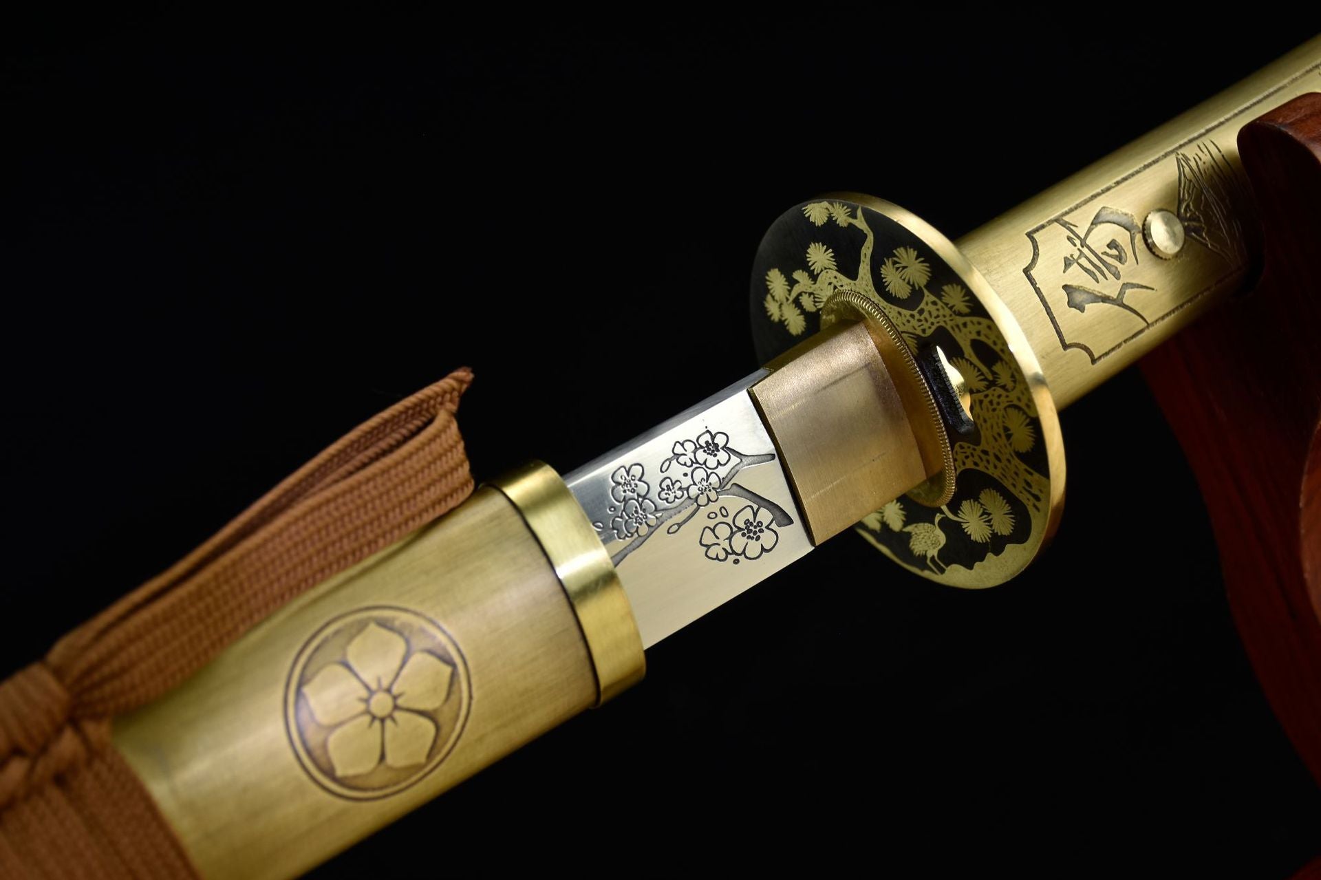 A katana featuring a sakura engraving on the blade, complemented by a brass tsuba and pommel.