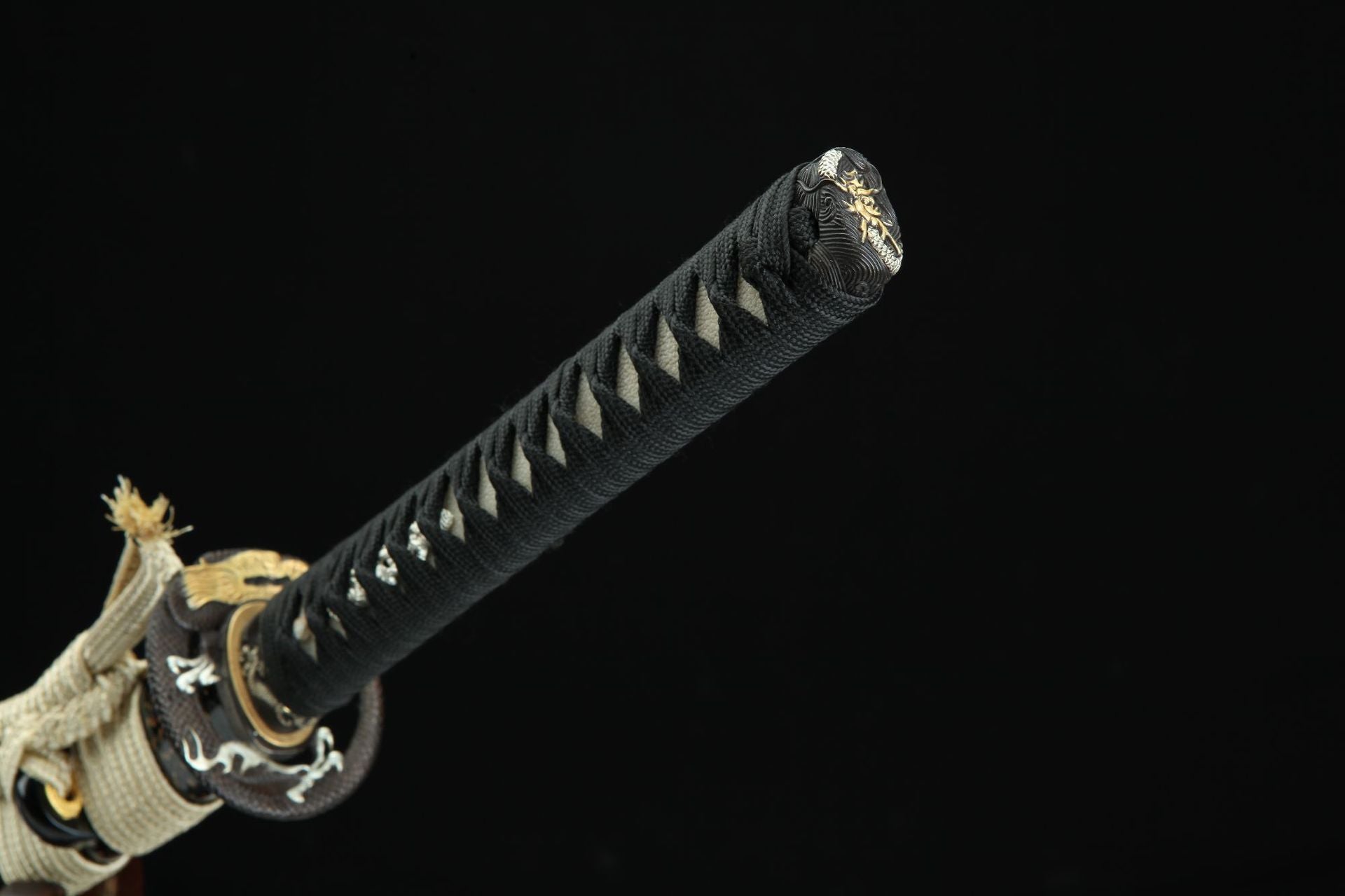 Close-up of the Loong Clow katana's kashira featuring a meticulously carved loong design.