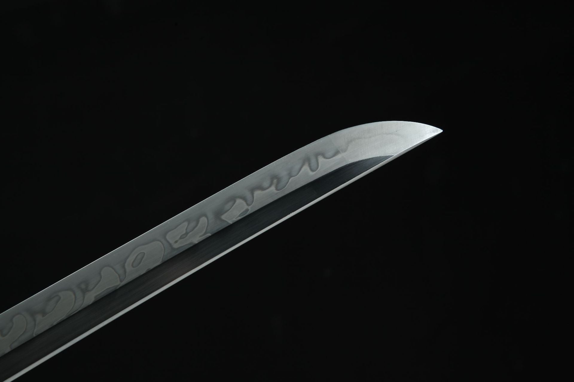 Close-up view of the Loong Clow katana's kissaki, showing the sharp tip and the hamon along the blade.