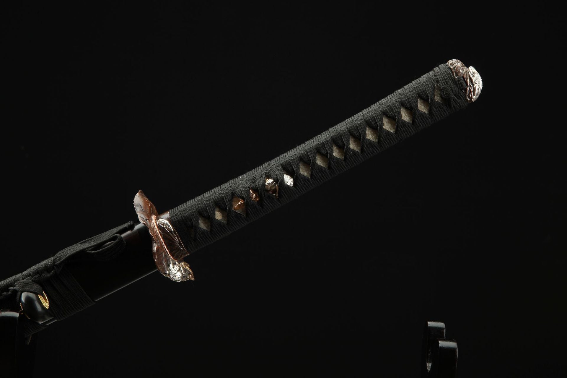 Detailed view of the Lotus katana's handle (tsuka) featuring a decorative wrap and intricate menuki.