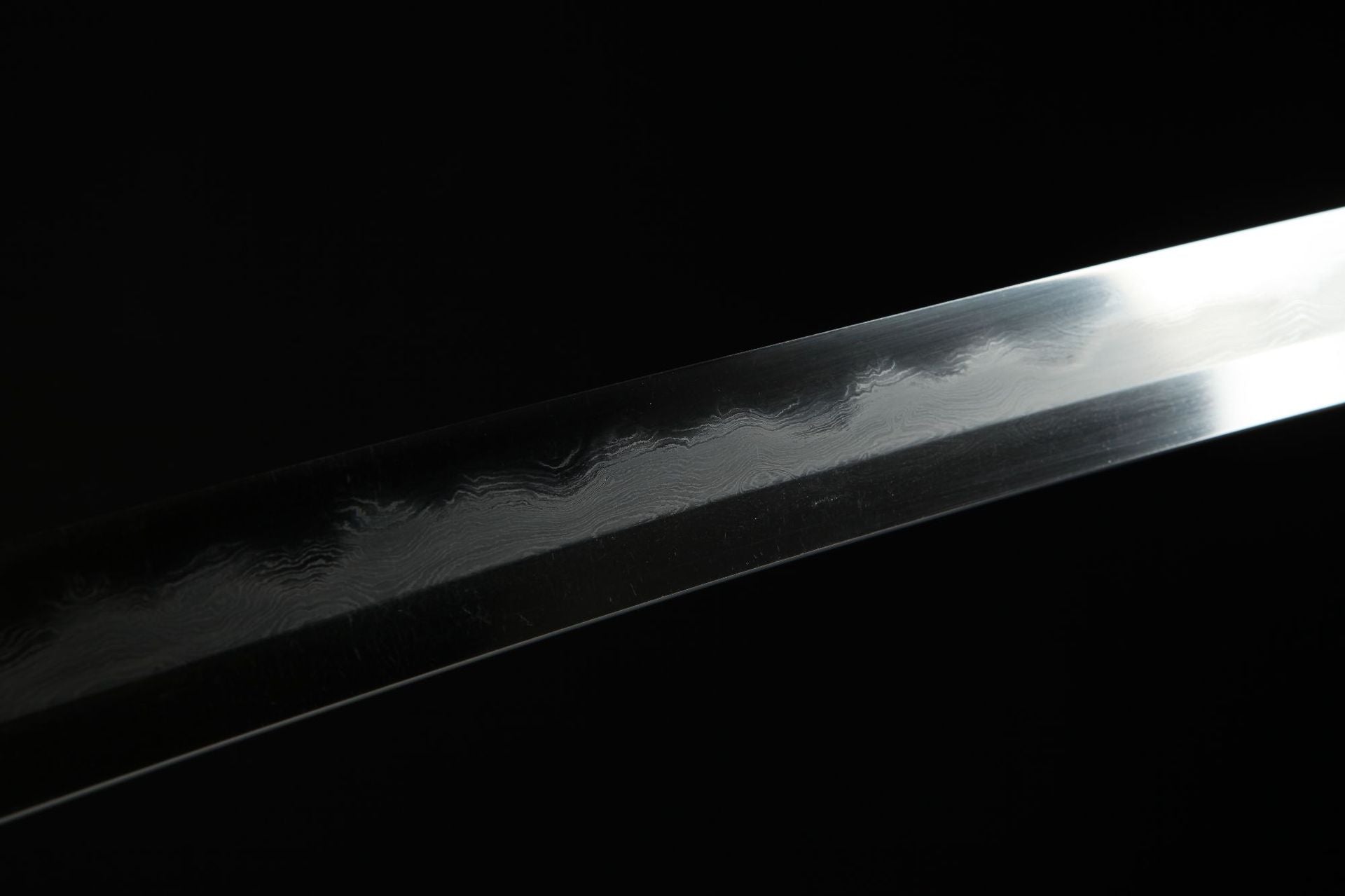 Close-up of the Mountain Lord katana blade showing the unique pattern of Damascus steel and hamon.