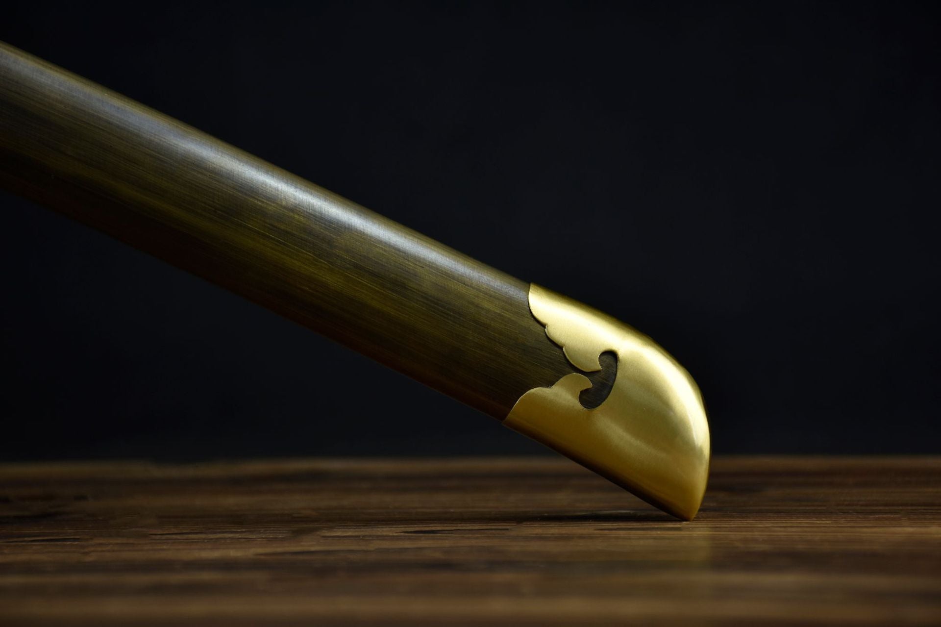 A natural wood scabbard for a Japanese sword, featuring a durable metal kurigata, blending traditional materials with modern functionality.